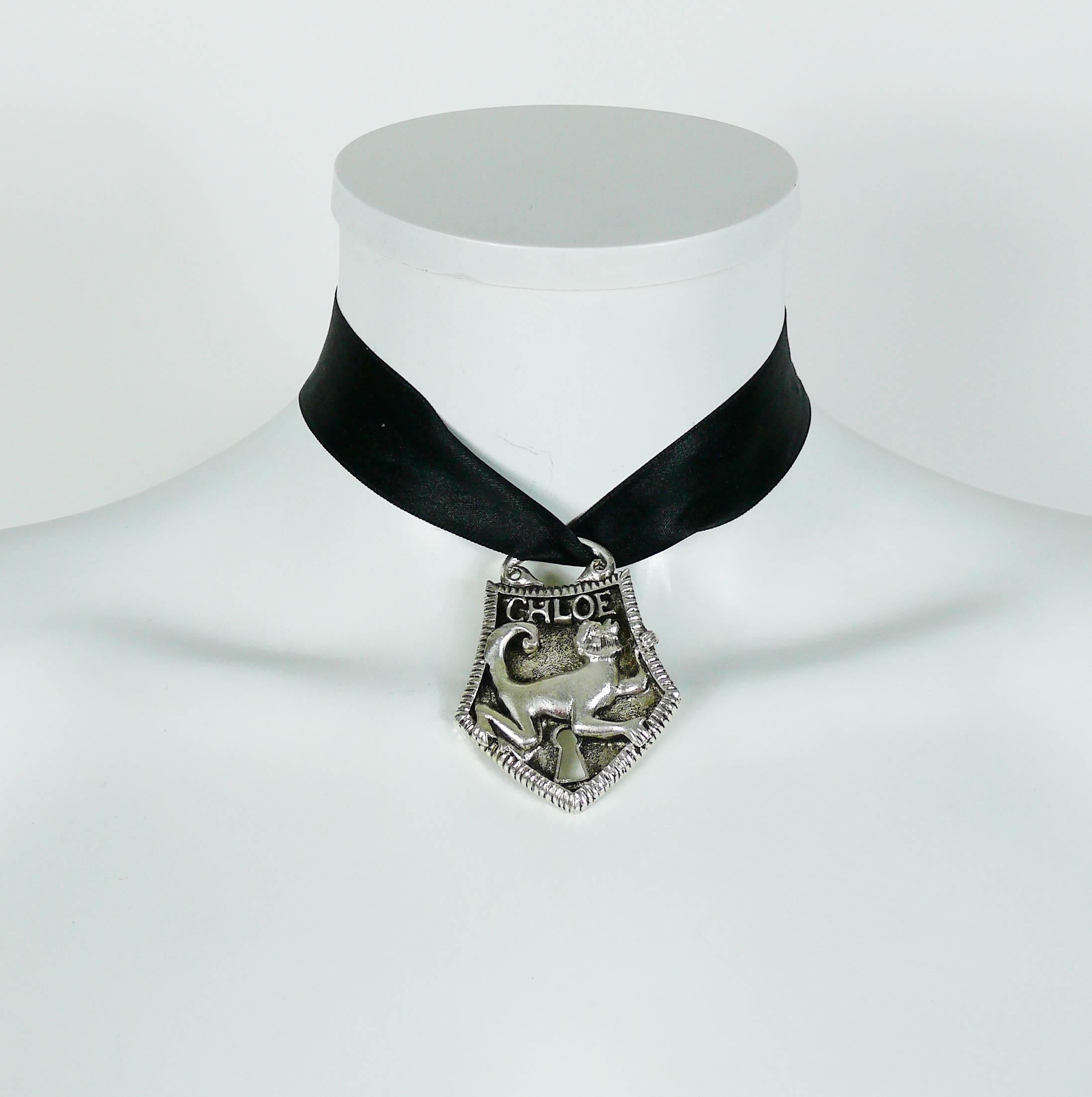 CHLOE antiqued silver tone pendant necklace featuring a monkey lock.

Black satin ribbon.

Embossed CHLOE.

Indicative measurements : ribbon length approx. 57 cm (22.44 inches) / pendant approx. 5.9 cm (2.32 inches) x 4.5 cm (1.77 inches).

JEWELRY