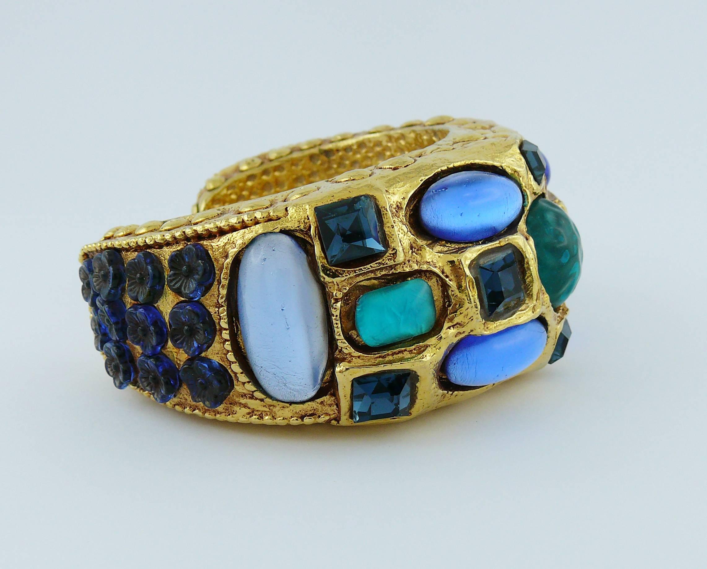 KALINGER vintage gold toned cuff bracelet embellished with blue crystals, blue glass flowers, glass and resin cabochons.

Marked KALINGER.

Indicative measurements : inner circumference approx. 16.65 cm (6.56 inches) / max width approx. 3.6 cm (1.42