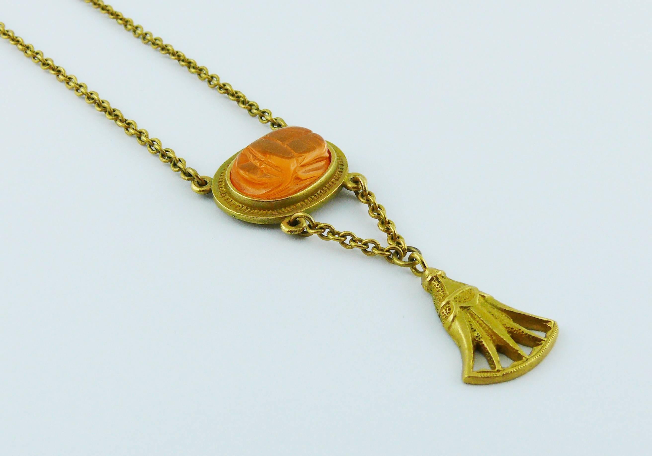 CHRSITIAN DIOR Egyptian revival matte gold toned necklace featuring a thin link chain, antique ornament and orange lucite scarab pendant.

Lobster clasp closure.

Spring/Summer collection 2004.

Marked DIOR ©.

Indicative measurements : length