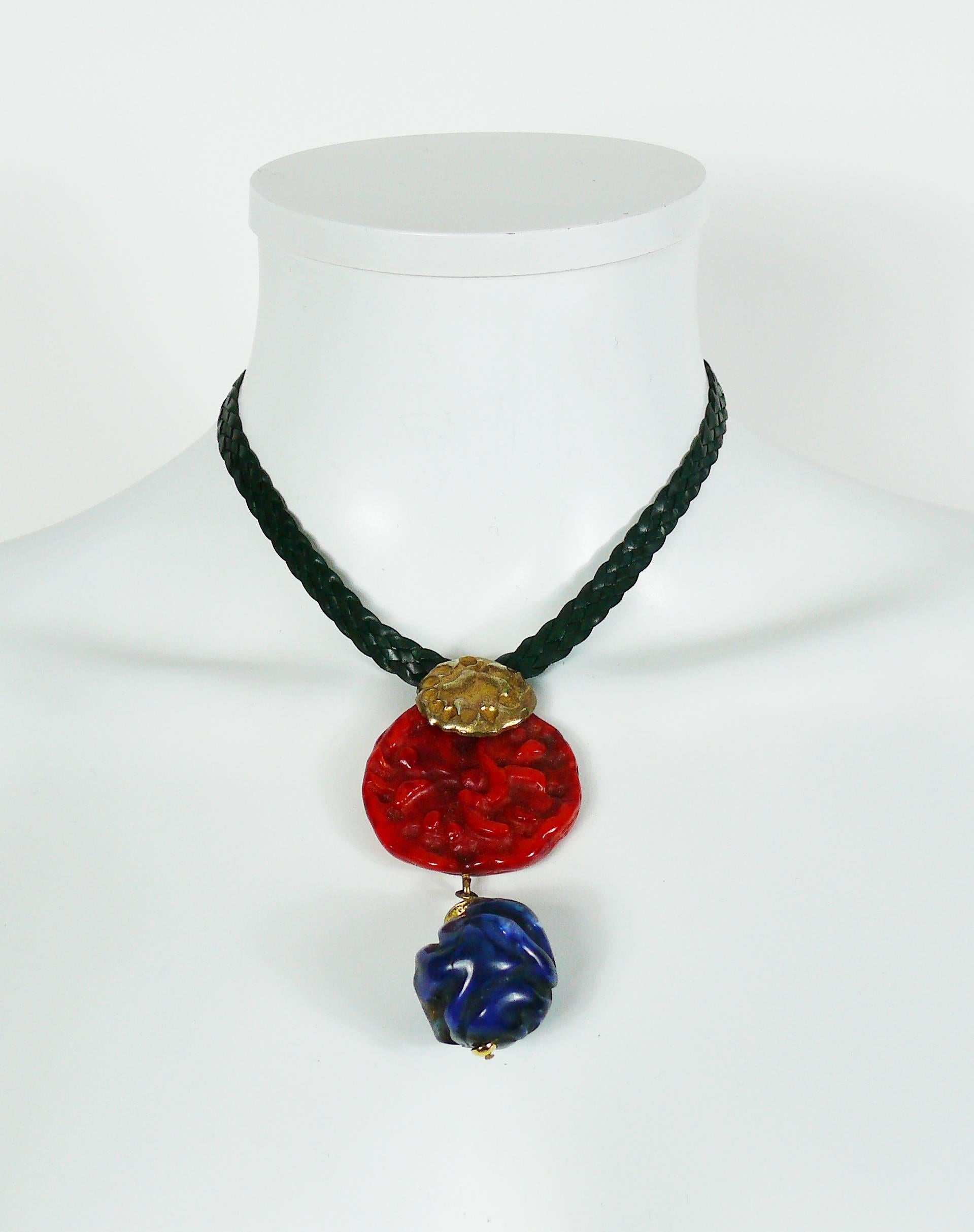 YVES SAINT LAURENT vintage Asisatic inspired necklace.

This necklace features a gorgeous pendant consisting of a gold toned textured coin, a large faux coral disc and a faux Lapis lazuli drop. Green leather strap.

Hook clasp closure.

Marked YVES