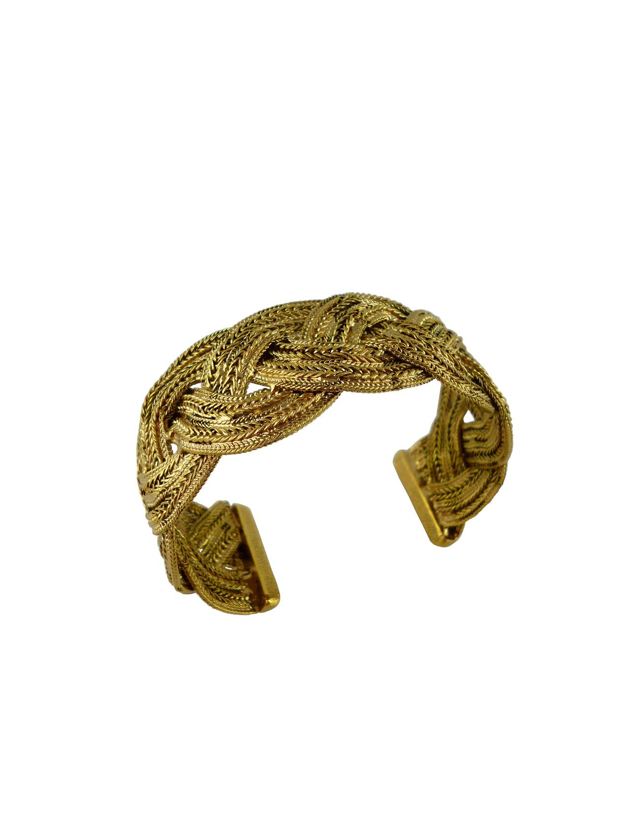 CHANEL semi rigid braided cuff bracelet featuring intertwined gold toned chains with antique patina.

Embossed CHANEL.

Indicative measurements : inner circumference approx. 19.80 cm (7.80 inches) /  width approx. 2.8 cm (1.10 inches).

This