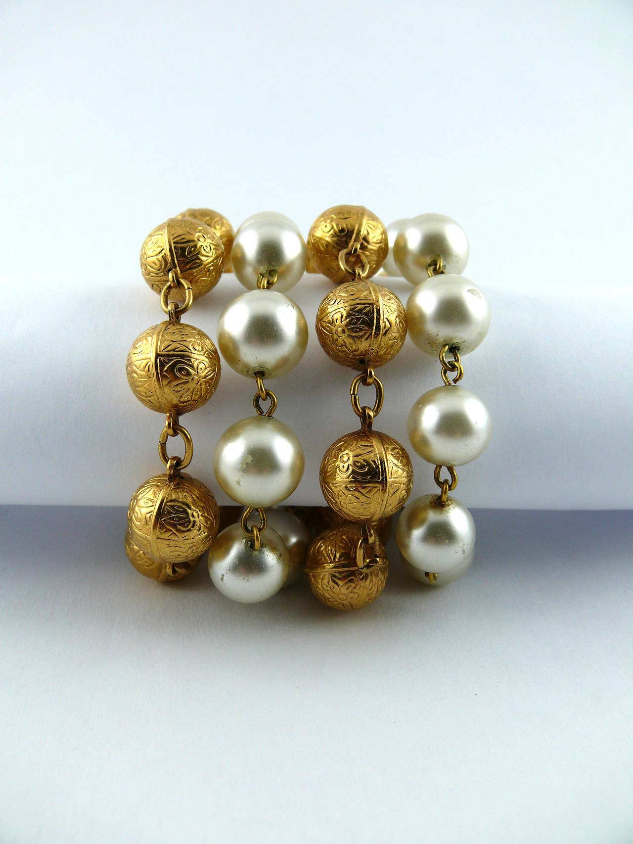 CHANEL vintage four strand bracelet featuring faux glass pearls and gold toned balls. Bracelet ends with a chain and CC logo charm.

Spring ring clasp closure

Embossed CHANEL Made in France.

Indicative measurements : length approx. 20 cm (7.87