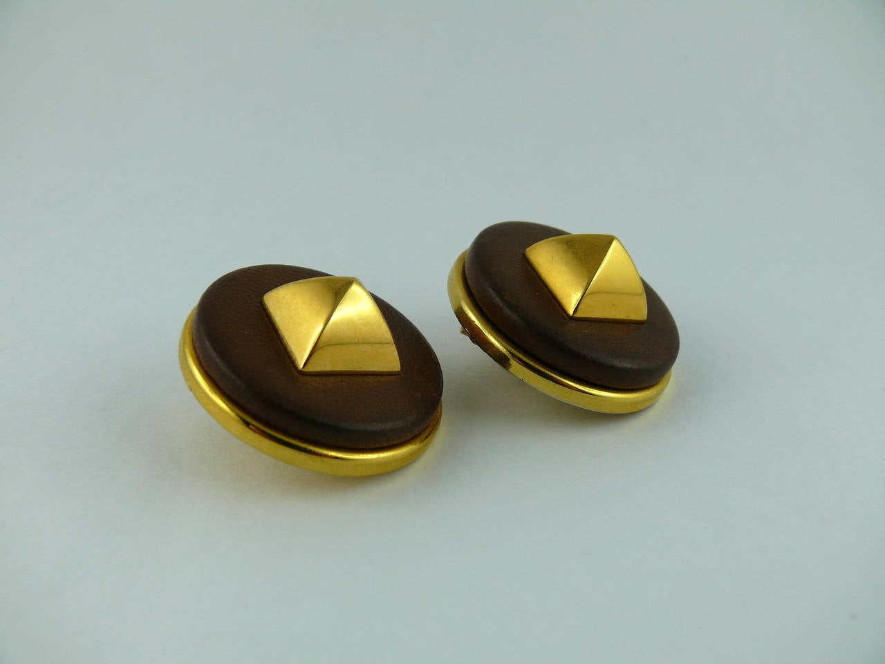 HERMES classic vintage Medor stud clip-on earrings.

Noisette color lambskin leather embellished with gold tone pyramid shaped studs.

Marked Hermes Paris.

Comes with Hermes box (used vintage condition).

JEWELRY CONDITION CHART
- New or