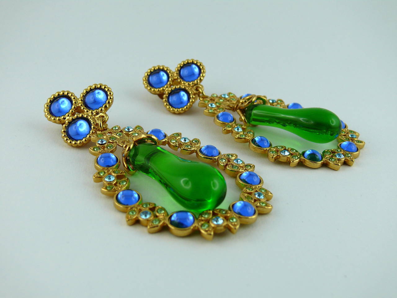 YVES SAINT LAURENT rare vintage crystal and poured glass dangling earrings (clip-on). Created in the ateliers of Robert Goossens.

Multi colored rhinestones and sapphire blue glass cabochons in a gold tone setting embellished with a massive green