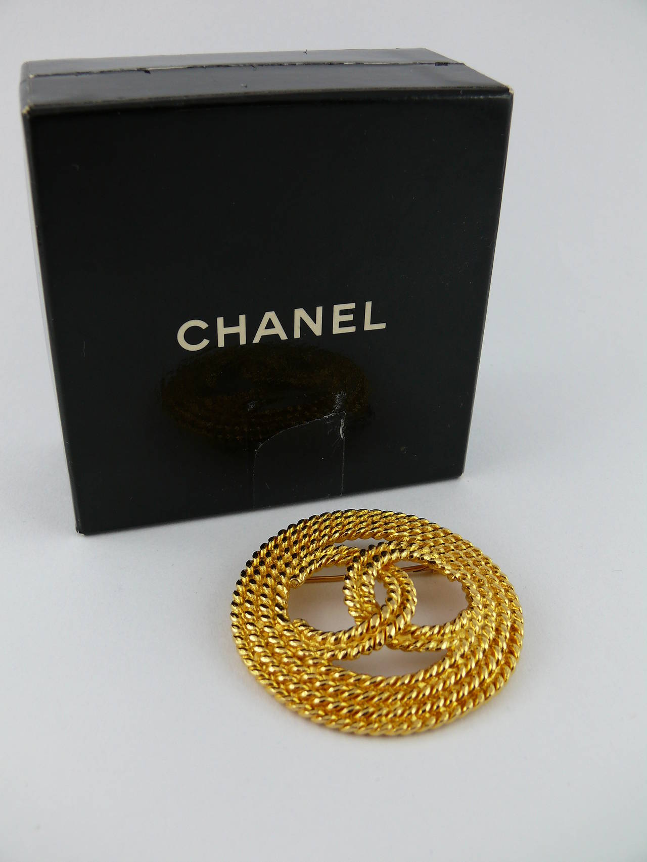 CHANEL vintage 1993 gold tone rope-like brooch featuring CC logo at the center.

Marked Chanel 2 8 Made in France.

Comes with its original box (used).

JEWELRY CONDITION CHART
- New or never worn : item is in pristine condition with no noticeable