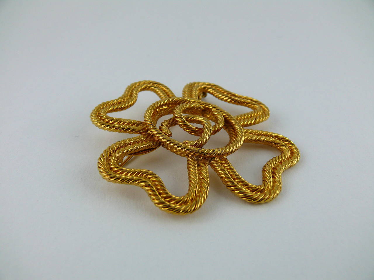 Chanel vintage gold tone clover rope-like brooch featuring CC monogram.

Collection year : 1993.

Marked Chanel 2 8 Made in France.

Indicative measurements : height aprox. 5.4 cm (2.13 inches) / width approx. 5.2 cm (2.05 inches).

JEWELRY