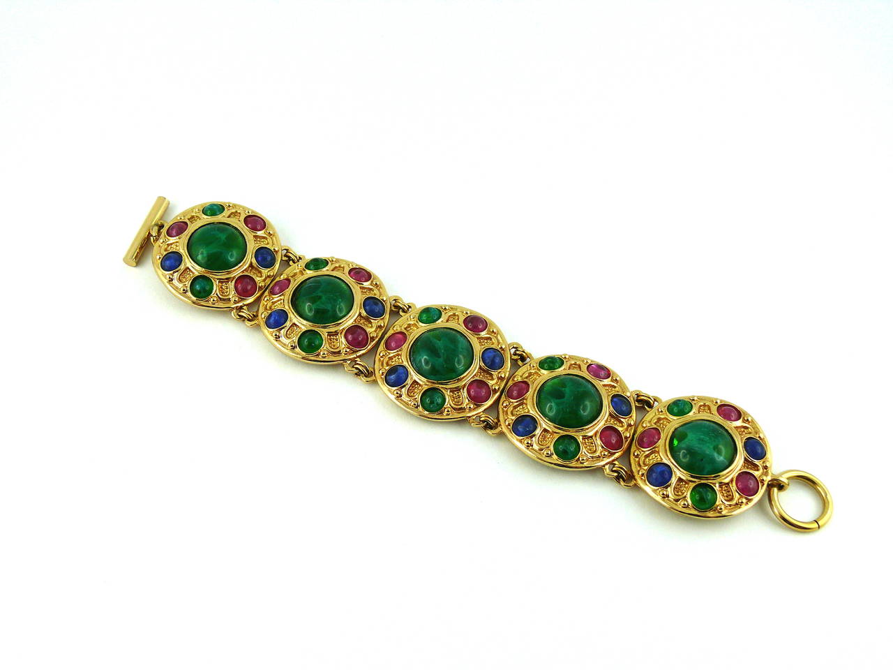 CHRISTIAN DIOR vintage Tutti Frutti gold toned link bracelet embellished with faux sapphire, emerald and ruby glass cabochons.

T bar closure.

Marked CHR. DIOR Germany.

Indicative measurements : length approx. 20.5 cm (8.07 inches) / link width