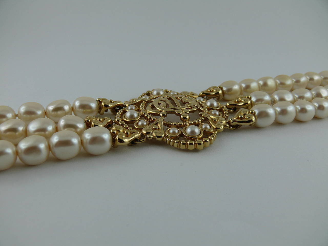 CHRISTIAN DIOR stunning vintage three tiered chunky faux pearl choker featuring a massive openwork logo medallion.

Marked Chr. Dior © Germany.

Indicative measurements : maximum length 38.5 cm / adjustable length from 33.5 cm to 38.5 cm