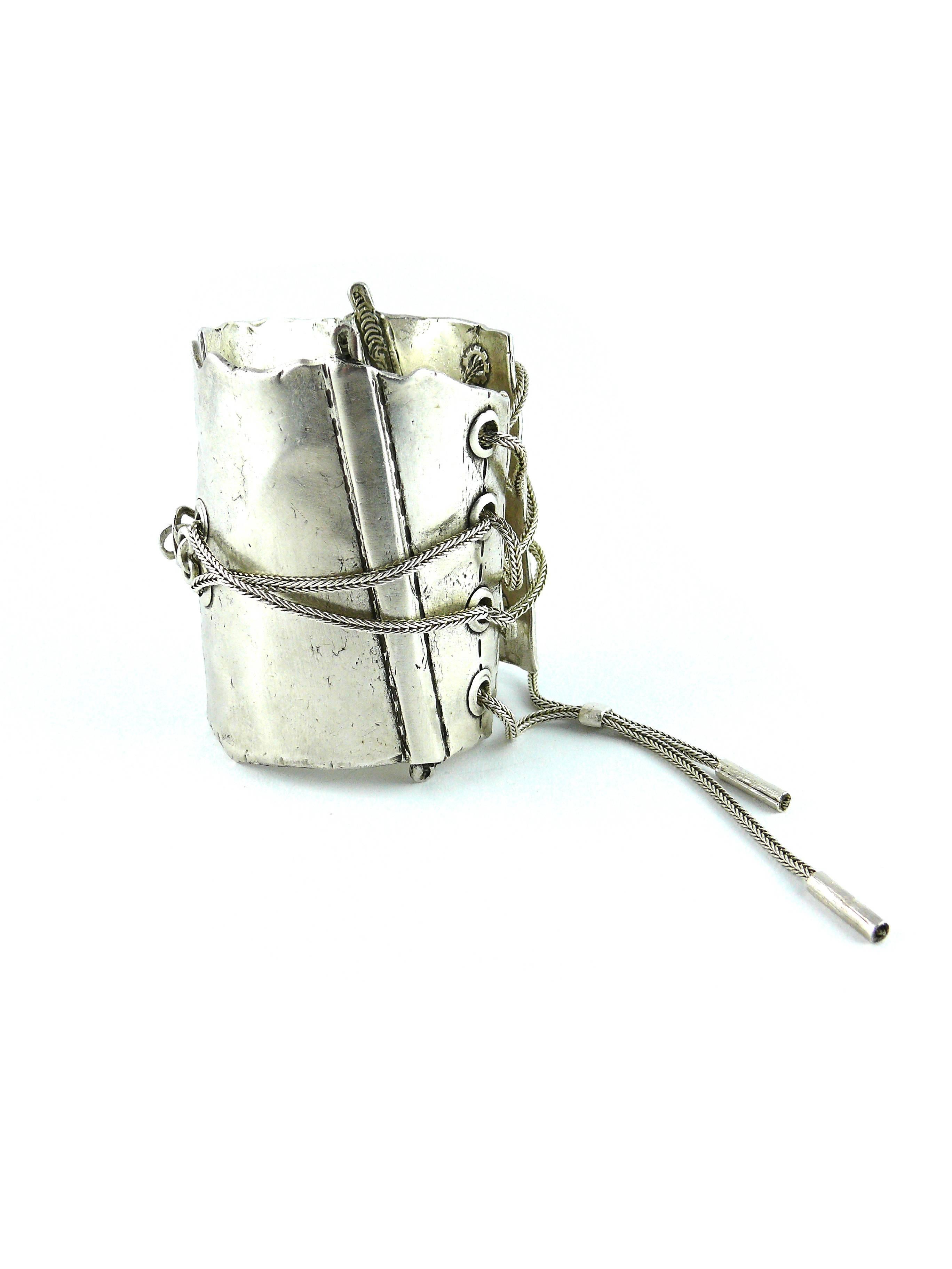 JEAN PAUL GAULTIER rarest sterling silver cuff bracelet featuring the iconic corset.

Very nicely detailed with whalebones, seams, reliefs, lacing and eyelets.

This bracelet closes at the back with a hook, and adjust with the lacing system to