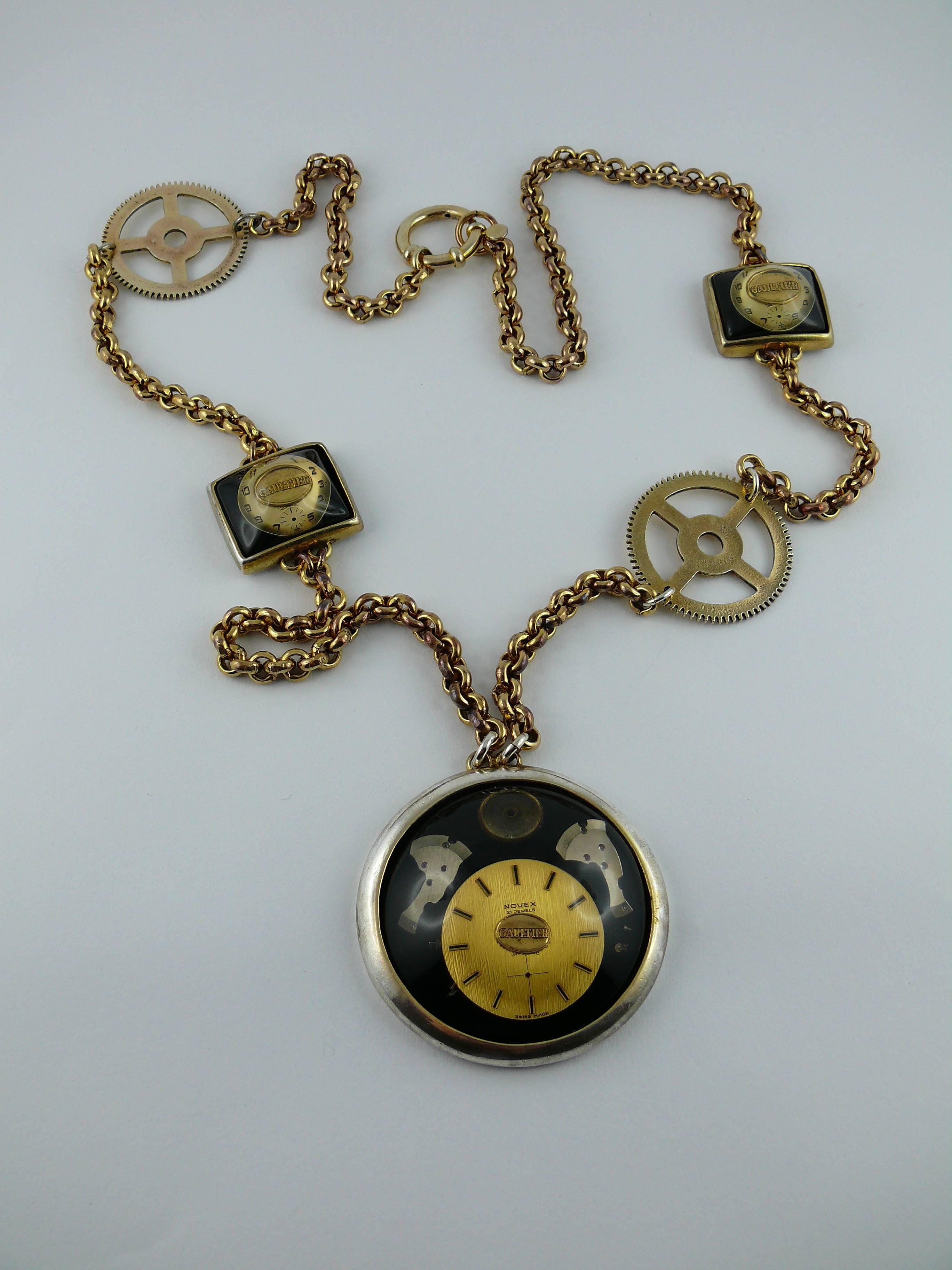 JEAN PAUL GAULTIER vintage steampunk watch necklace.

Chunky gold tone chain featuring gears, two small watch dials and a massive watch pendant.

Spring ring closure.

Marked GAULTIER.

Indicative measurements : length of the chain approx 91.5 cm