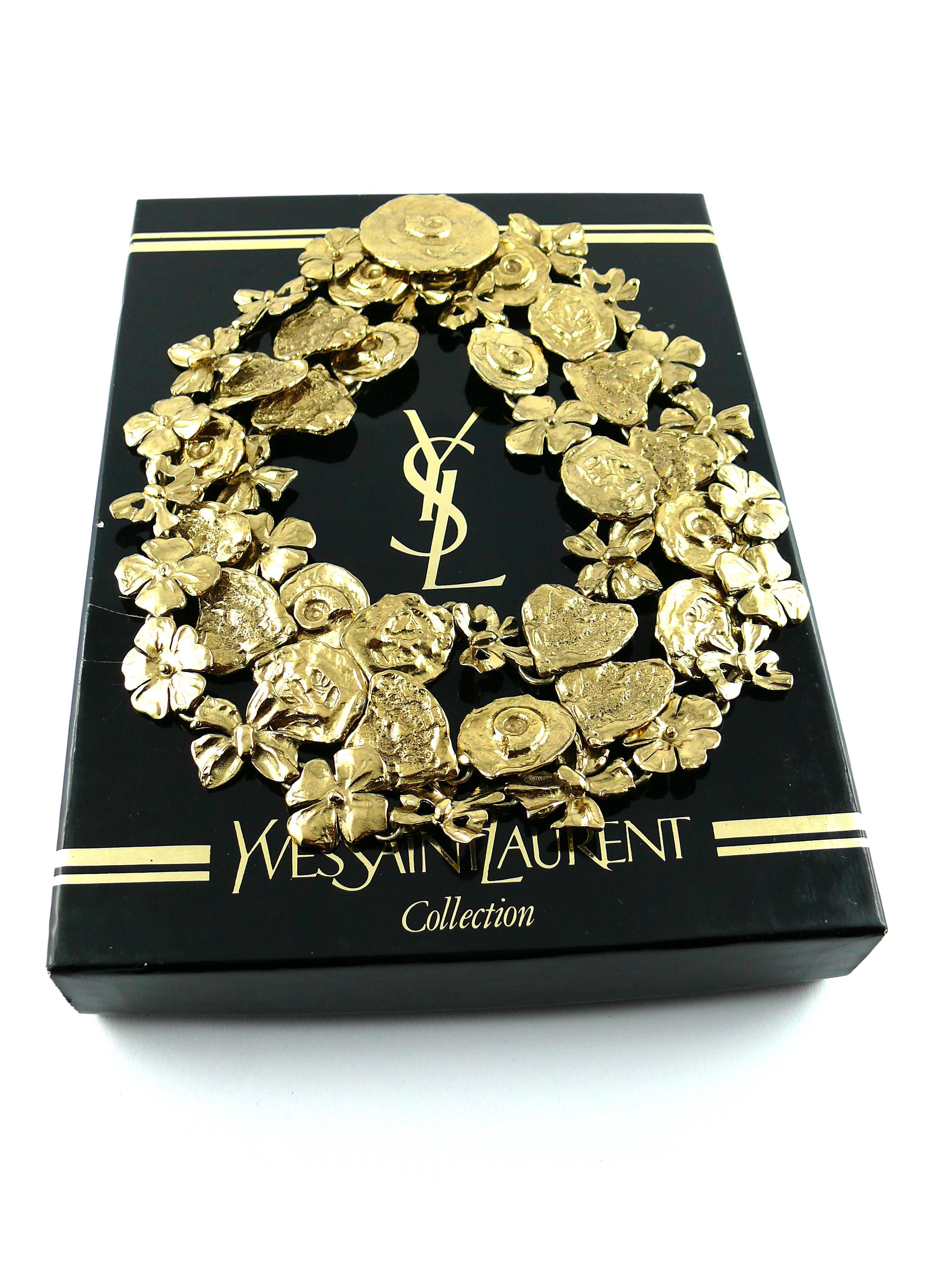 YVES SAINT LAURENT vintage rare opulent three-tier articulated necklace created by parurier ROBERT GOOSSENS.

Gold tone textured metal with antique patina featuring fossil coins, bows, stylized hearts and flowers.

Hidden hook closure.

Marked