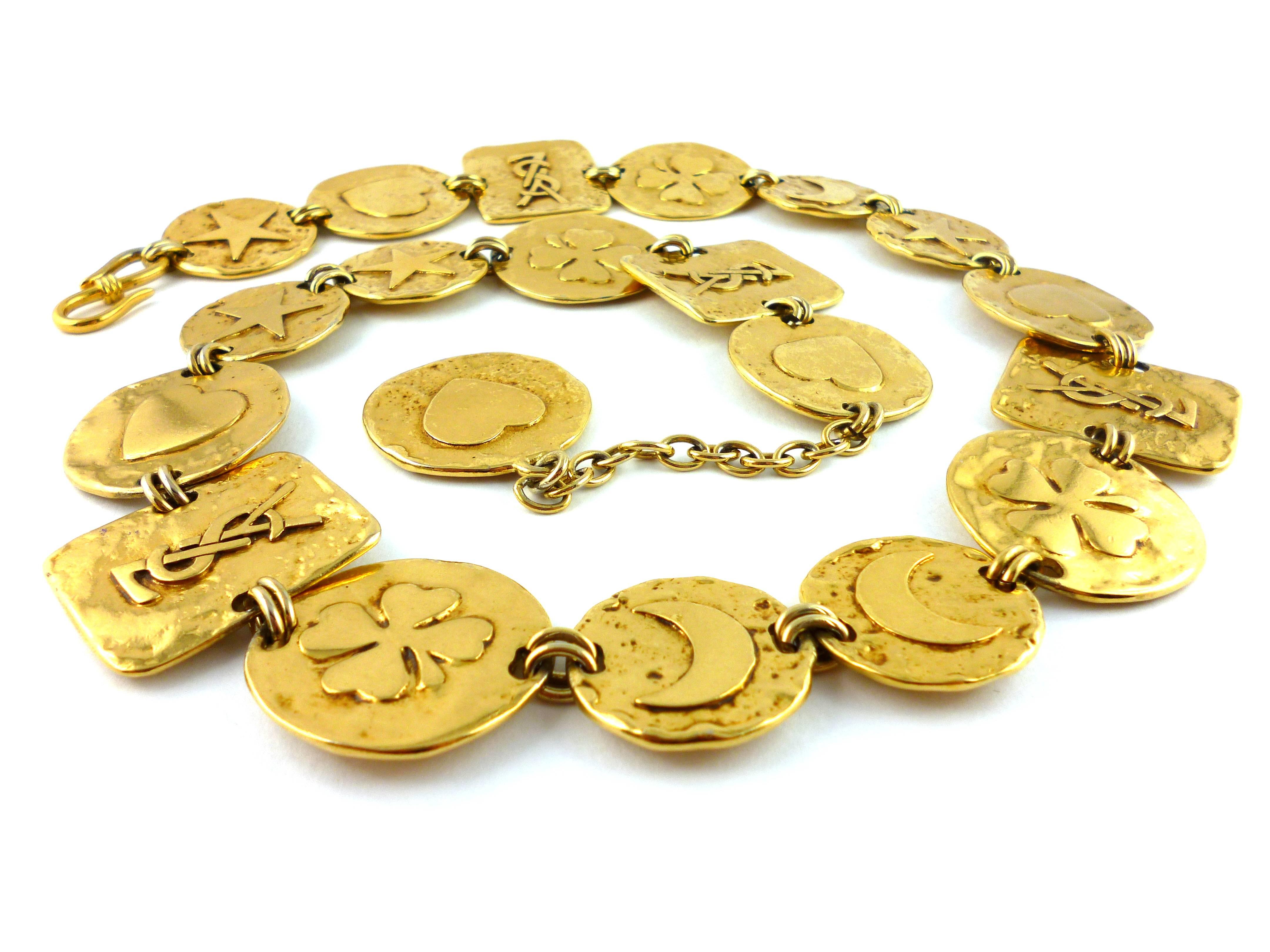 YVES SAINT LAURENT vintage belt/necklace featuring articulated gold tone square plates and coins engraved with iconic symbols :  crescent moons, stars, clovers, hearts and 