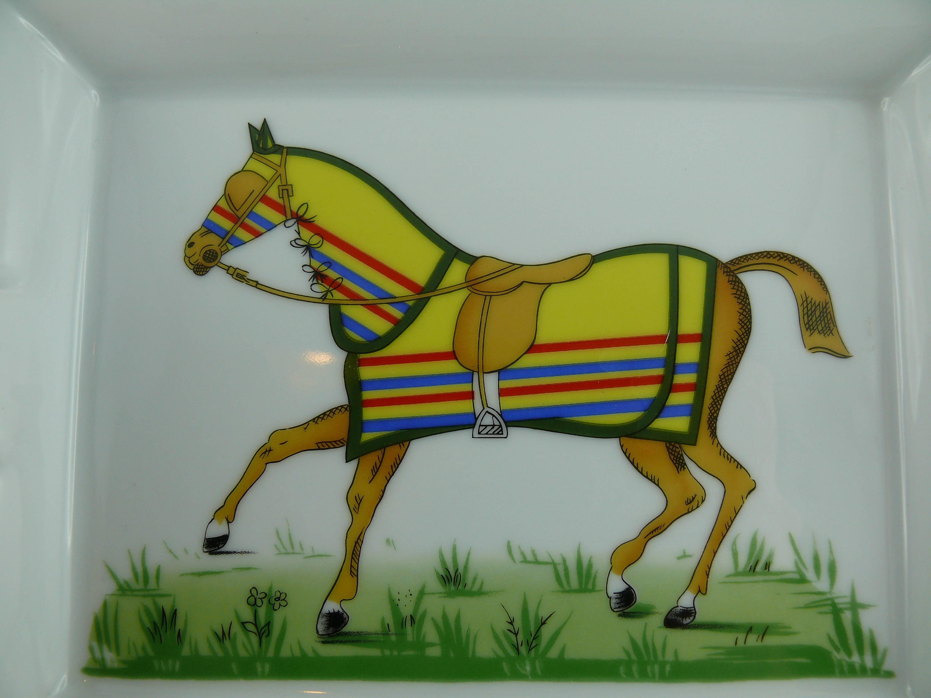 HERMES Paris large white porcelain cigar ashtray or pin tray printed with exquisite multi colored equestrian image. 

Red, yellow and gilt geometrical rims.

Marked HERMES Paris and Made in France.

Note
As a buyer, you are fully responsible