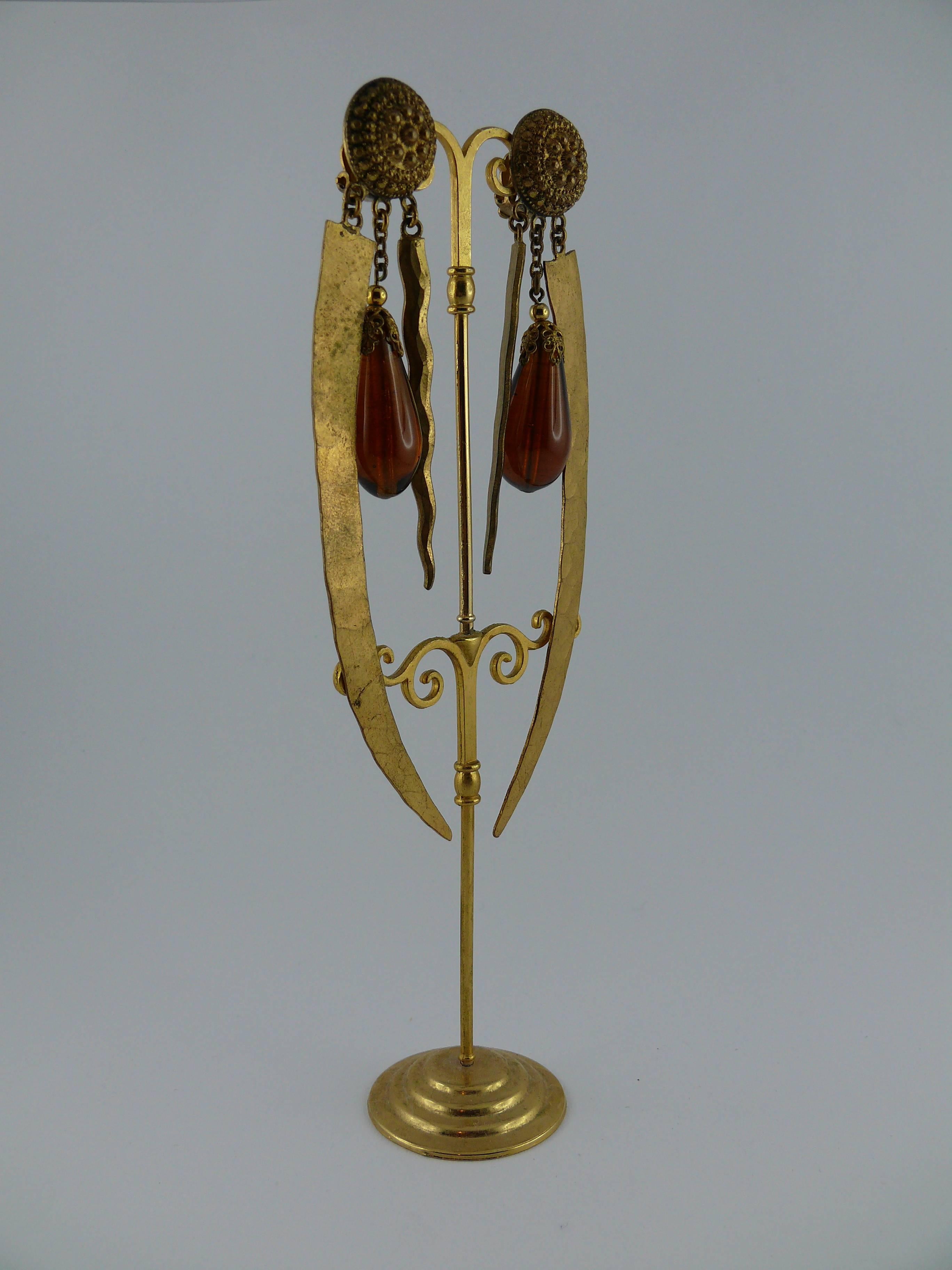 YVES SAINT LAURENT vintage rare early oriental style shoulder duster dangling earrings (clip-on).

These earrings consist of two daggers and a large amber glass drop.
Top part features a nicely detailed shield.

Embossed YSL.

Note
As a
