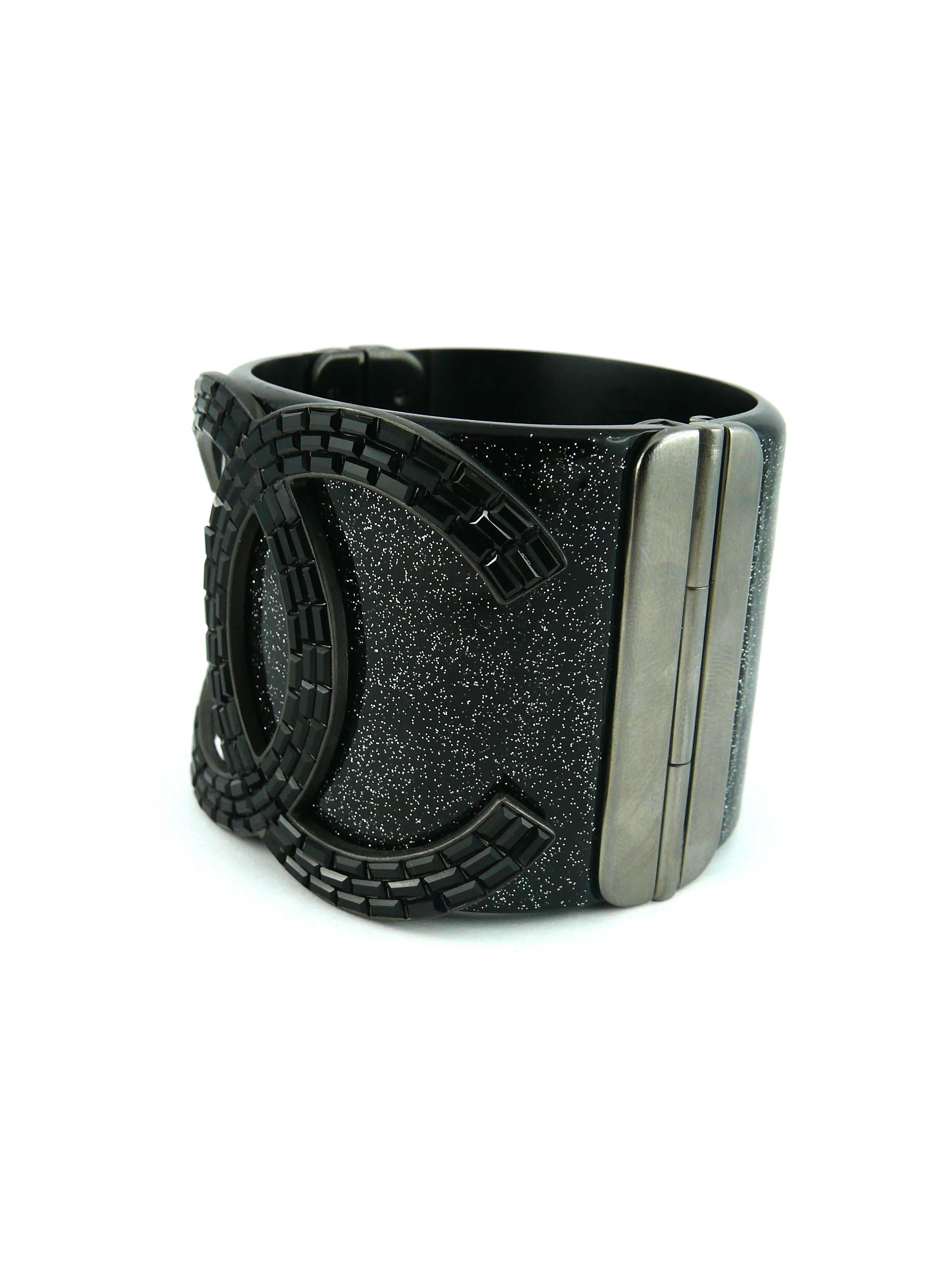 CHANEL rare glittering black resin cuff bracelet featuring a massive CC logo set with jet Swarovski crystal baguettes.

Spring / Summer Collection 2009.

Hinge clasp embossed with CC logo.

Stamped CHANEL 09 P Made in Italy.

Indicative