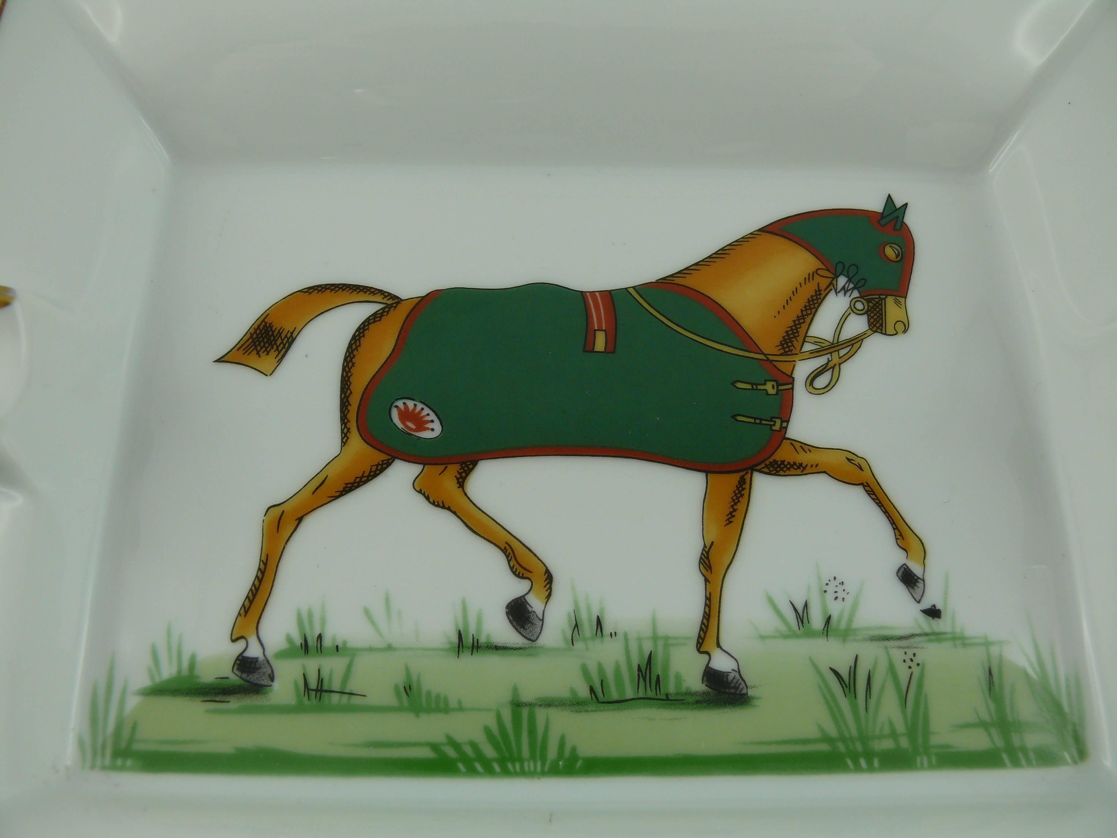 HERMES Paris large white porcelain cigar ashtray or pin tray printed with exquisite multi colored equestrian image. 

Green, yellow and gilt geometrical rims.

Marked HERMES Paris and Made in France.

Note
As a buyer, you are fully