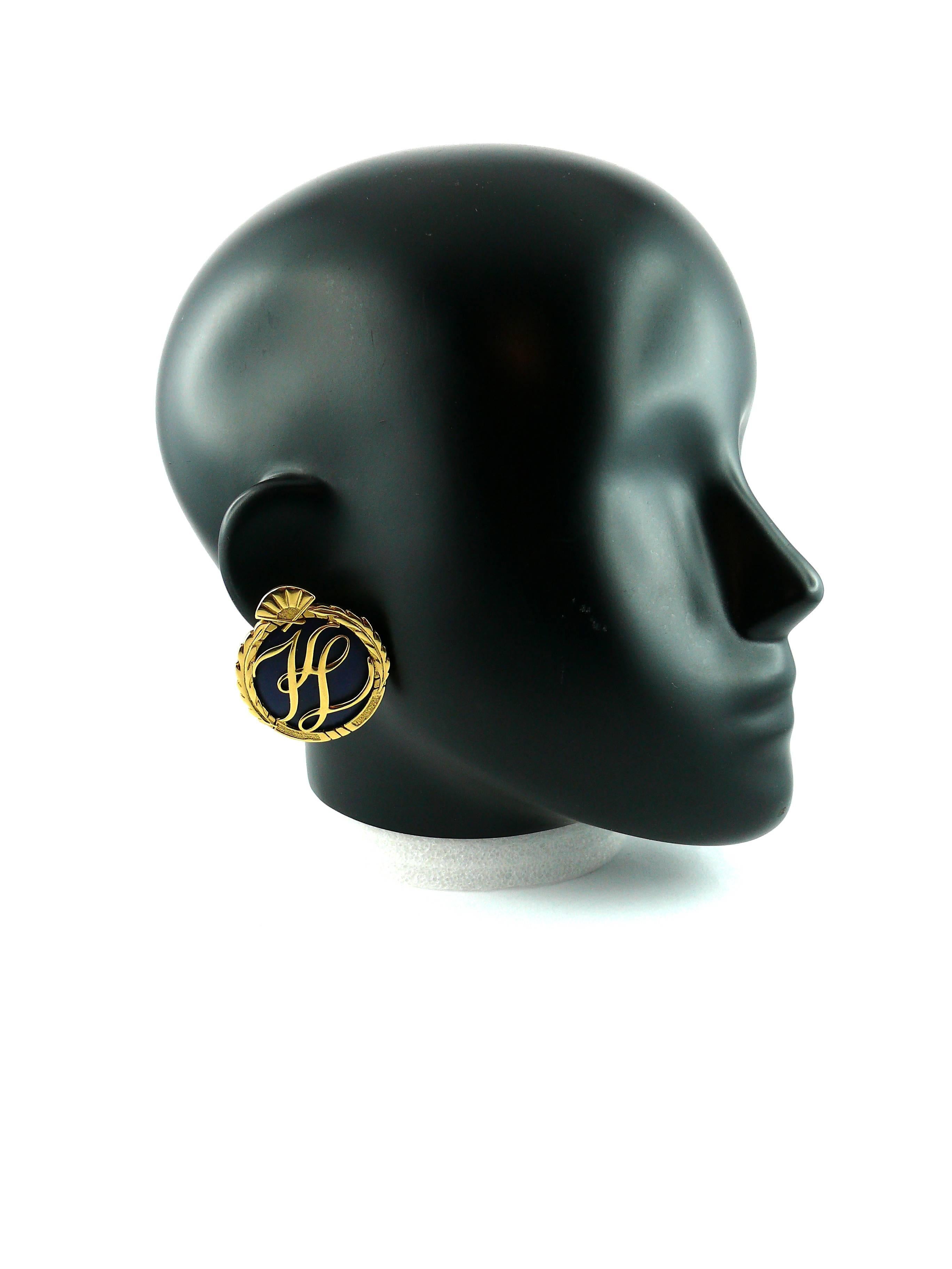 KARL LAGERFELD vintage oversized clip-on earrings in gold tone with deep blue lucite inlaid.

These earring feature designer mongram surrounded by laureus garlands and topped with iconic fan.

Embossed KL.

JEWELRY CONDITION CHART
- New or never