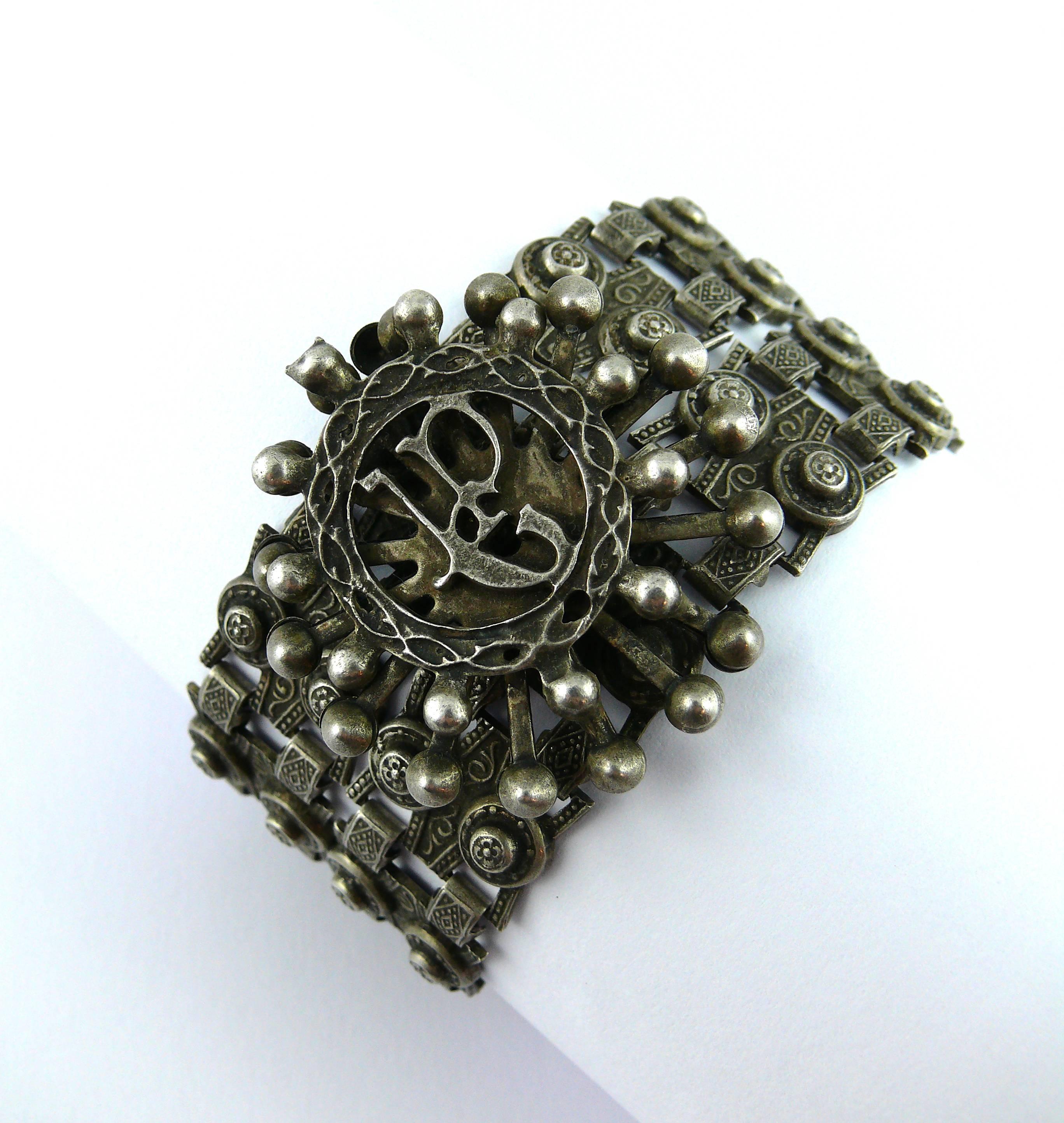 JEAN PAUL GAULTIER vintage 1990s articulated bracelet.

Silver toned with antique patina oriental style links featuring a central radiant sun with JPG monogram.

JEWELRY CONDITION CHART
- New or never worn : item is in pristine condition with no