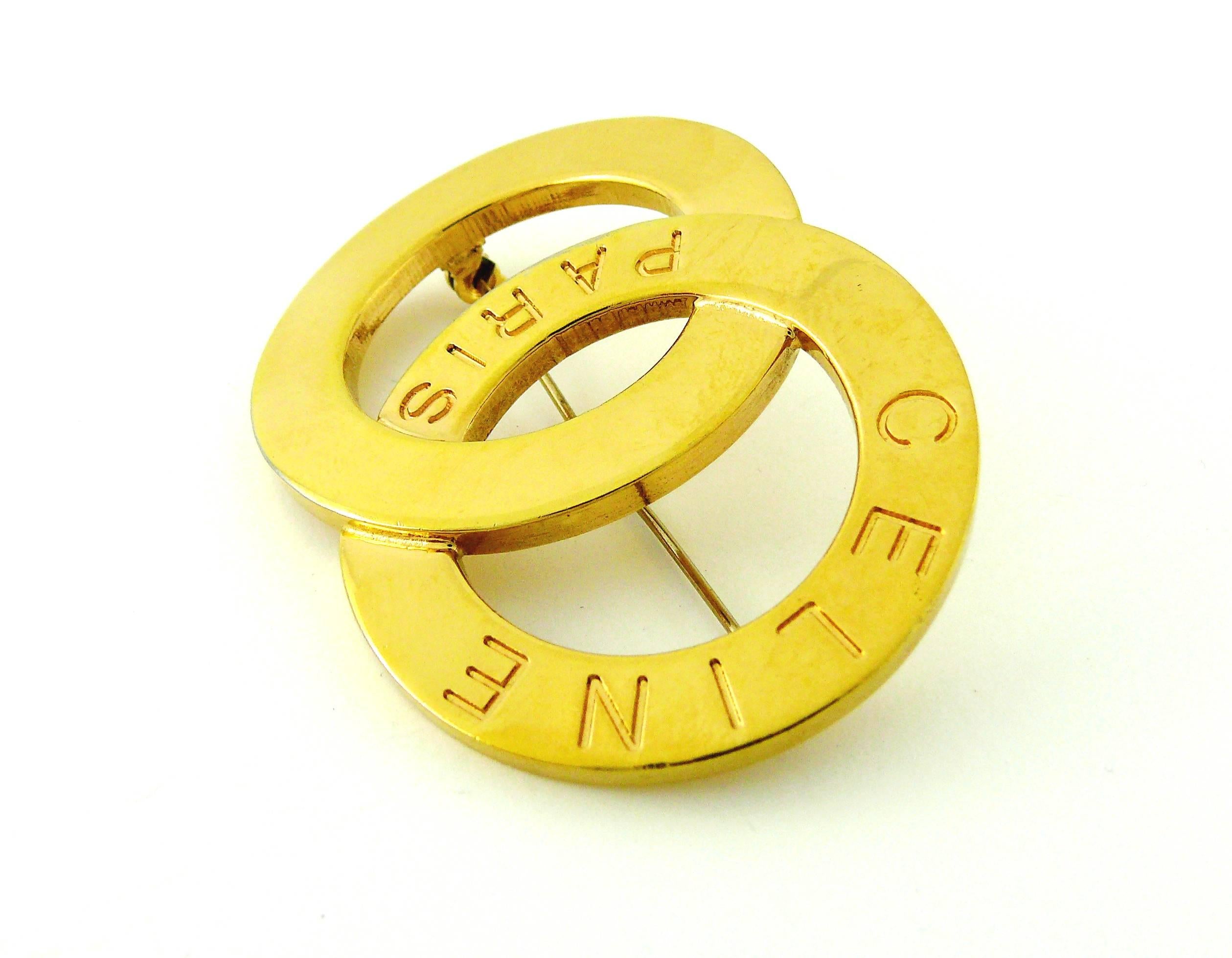CELINE Paris vintage gold toned double ring brooch.

Embossed CELINE Paris at the front.
Marked CELINE LE Made in Italy on the reverse.

JEWELRY CONDITION CHART
- New or never worn : item is in pristine condition with no noticeable imperfections
-