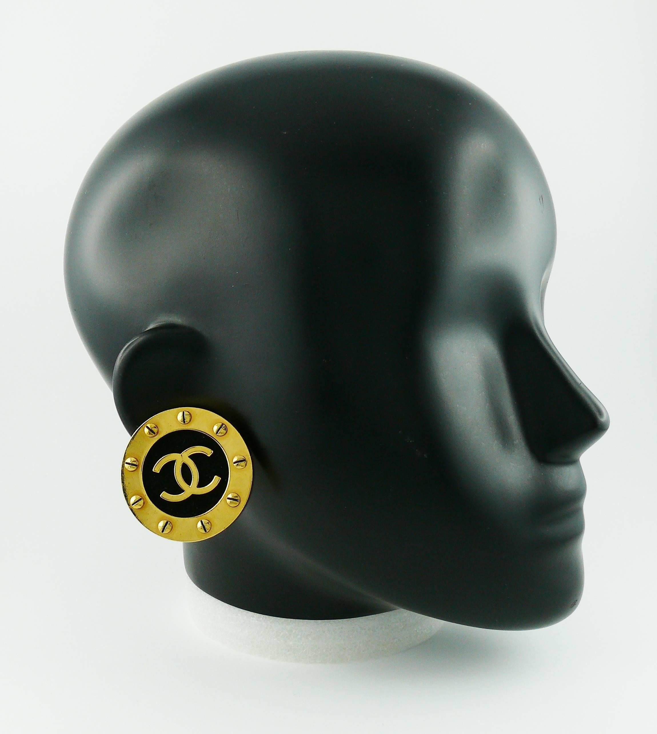 CHANEL vintage 1990s massive gold toned screw stud clip-on earrings.

These earrings feature screw stud trim with a CC logo monogram in the center on a black suede background.

Embossed CHANEL 2 9 Made in France.

JEWELRY CONDITION CHART
- New or