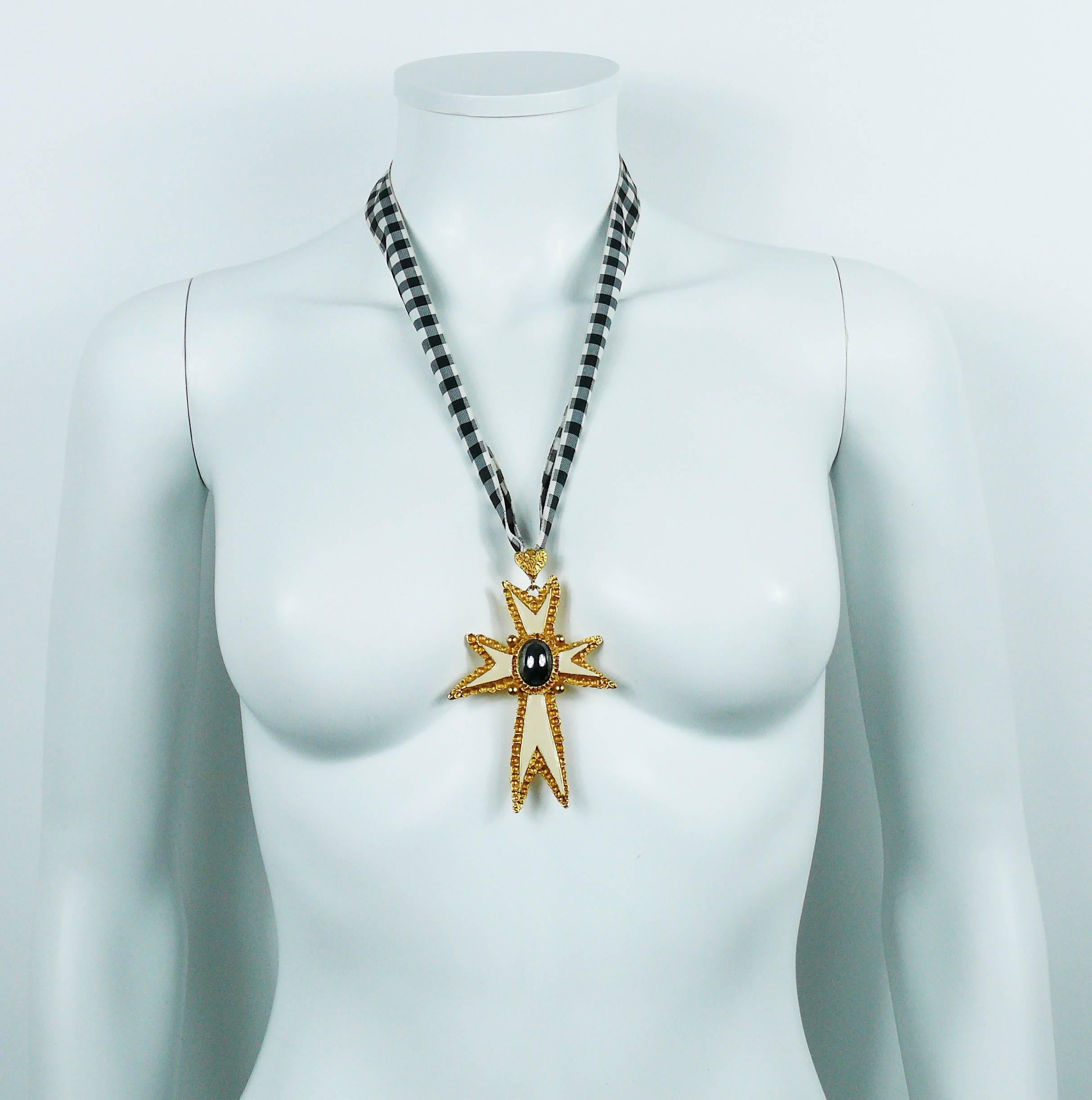 CHRISTIAN LACROIX vintage 1994 pendant necklace featuring a gold tone enameled cross with hematite cabochon embellishement.

Original checkered ribbon.

Marked CHRISTIAN LACROIX E94 Made in France.

Indicative measurements : length worn approx. 33