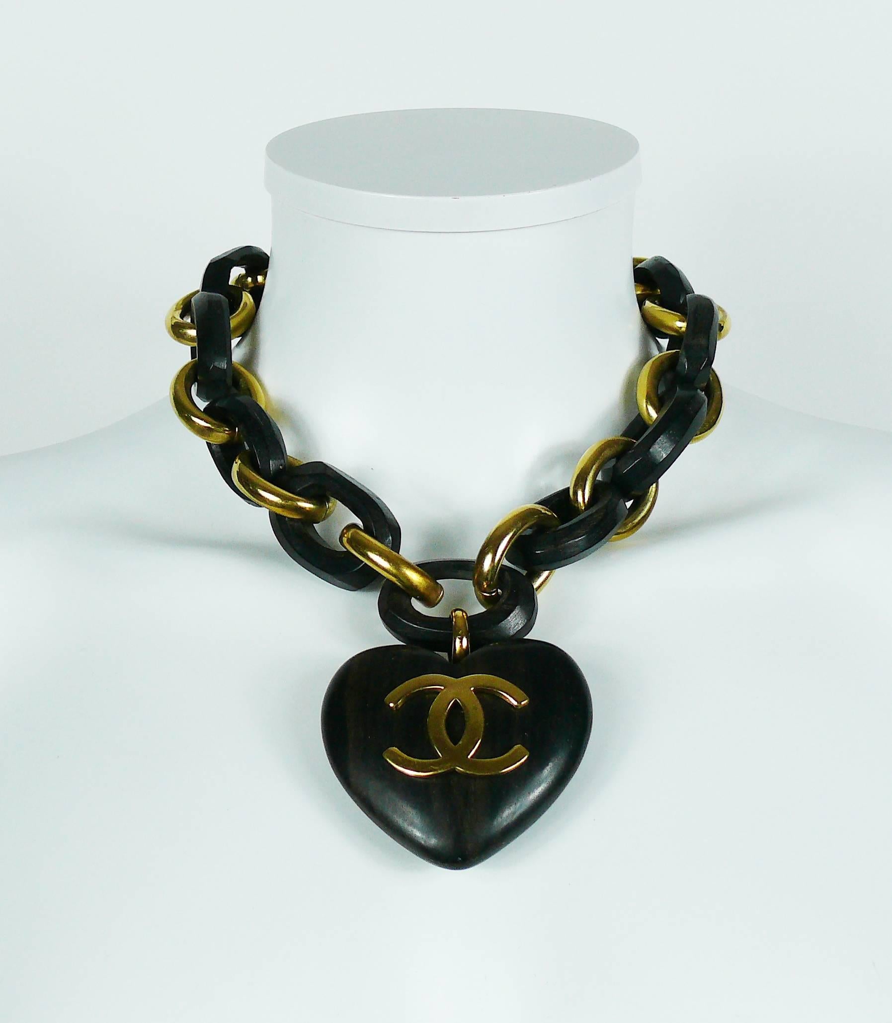 CHANEL vintage hard to find iconic necklace featuring a massive wooden heart pendant with CC logo. The chain is made of bold gold toned and carved wood links. 

Hook closure.

Season 28 - Year : 1993.

Marked CHANEL 2 8 Made in France.

Indicative