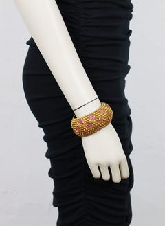 Bracelet manchette YVES SAINT LAURENT (YSL) vintage, doré, orné de cristaux roses et de pierres précieuses