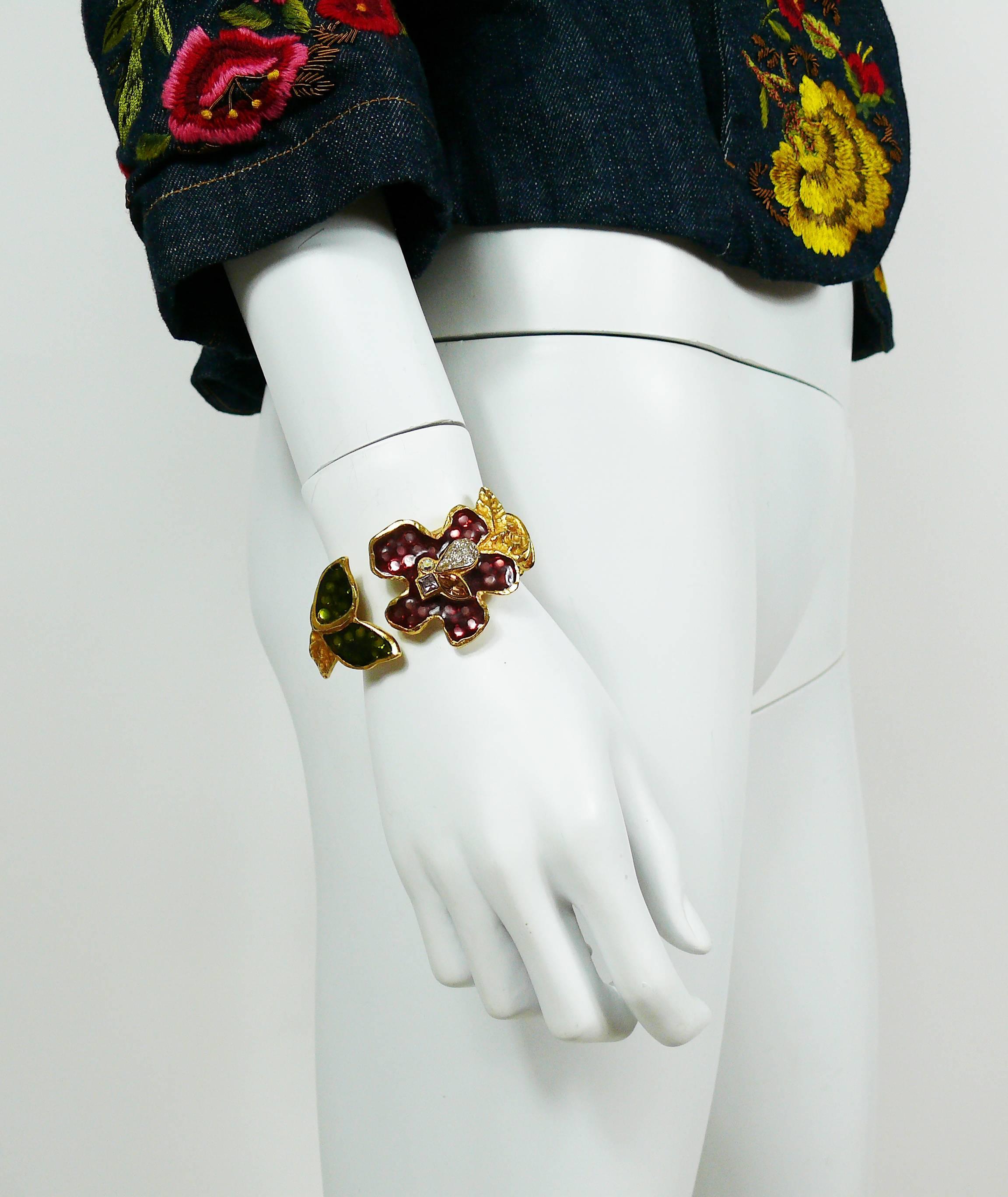 CHRISTIAN LACROIX vintage gold tone clamper bracelet featuring multicolored enamel flowers with crystal embellishement.

Marked CHRISTIAN LACROIX CL Made in France.

Indicative measurements : inner circumference approx. 16.34 cm (6.43 inches) / max.