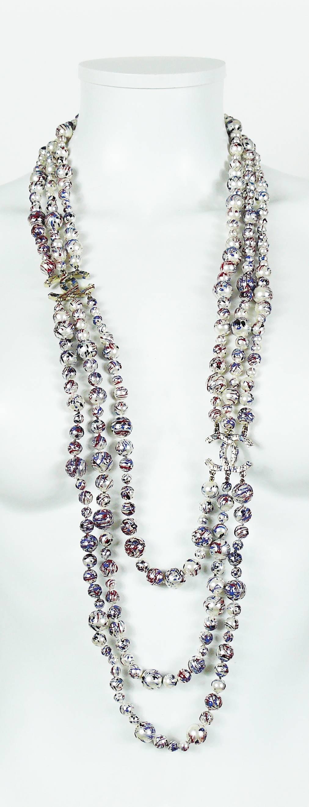 CHANEL Fall 2013 collectable and rare red-blue splatter paint faux pearl triple strand necklace featuring CC logos.

This necklace features :
- Gorgeous design inspired by the painting techniques of American artist JACKSON POLLOCK.
- Glass faux