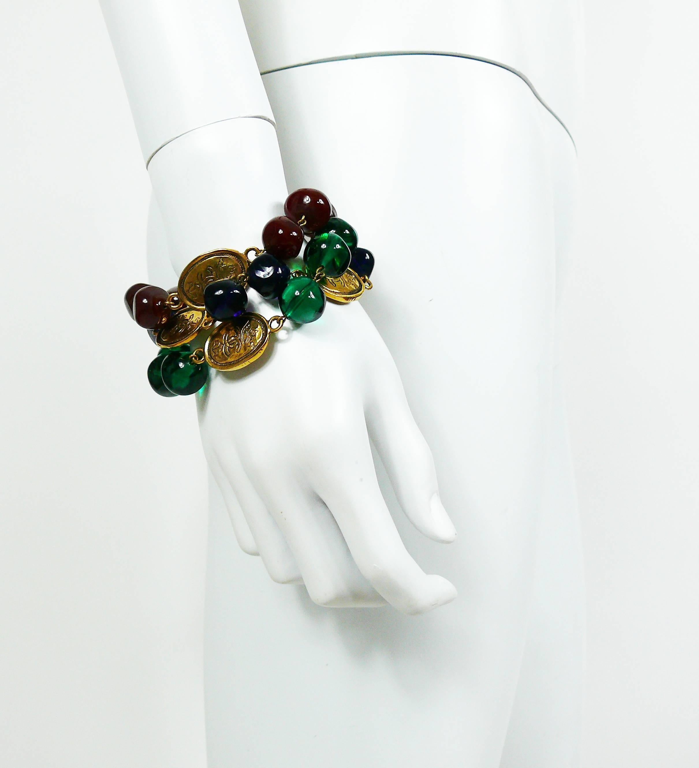 CHANEL vintage triple strand bracelet featuring blue-red-green GRIPOIX glass beads and gold toned crowned CC coins.

Collection year : 1991.

Spring clasp closure.
Extension chain.

Marked CHANEL 2 6 Made in France.

Indicative measurements : length