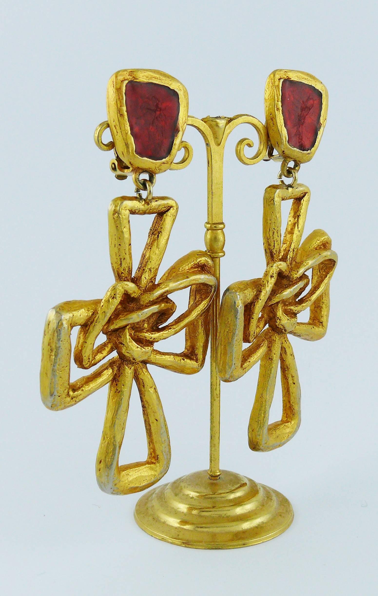 CHRISTIAN LACROIX vintage massive gold toned dangling earrings (clip-on) featuring a wired cross with a red resin top.

Marked CHRISTIAN LACROIX CL Made in France.

Indicative measurements : length approx. 9.4 cm (3.70 inches) / max. width approx.