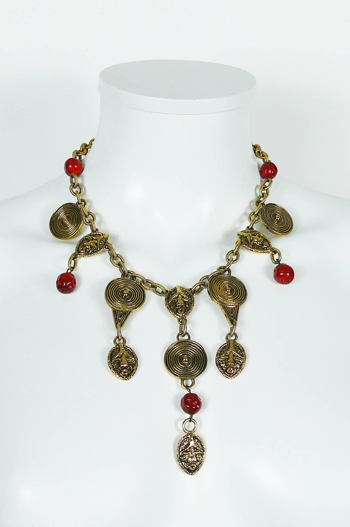 GUY LAROCHE vintage antiqued gold tone African inspired necklace featuring discs, masks and faux coral glass beads.

T-bar closure.

Indicative measurements : length approx. 46 cm (18.11 inches) / max. drop approx. 10 cm (3.94 inches).

JEWELRY