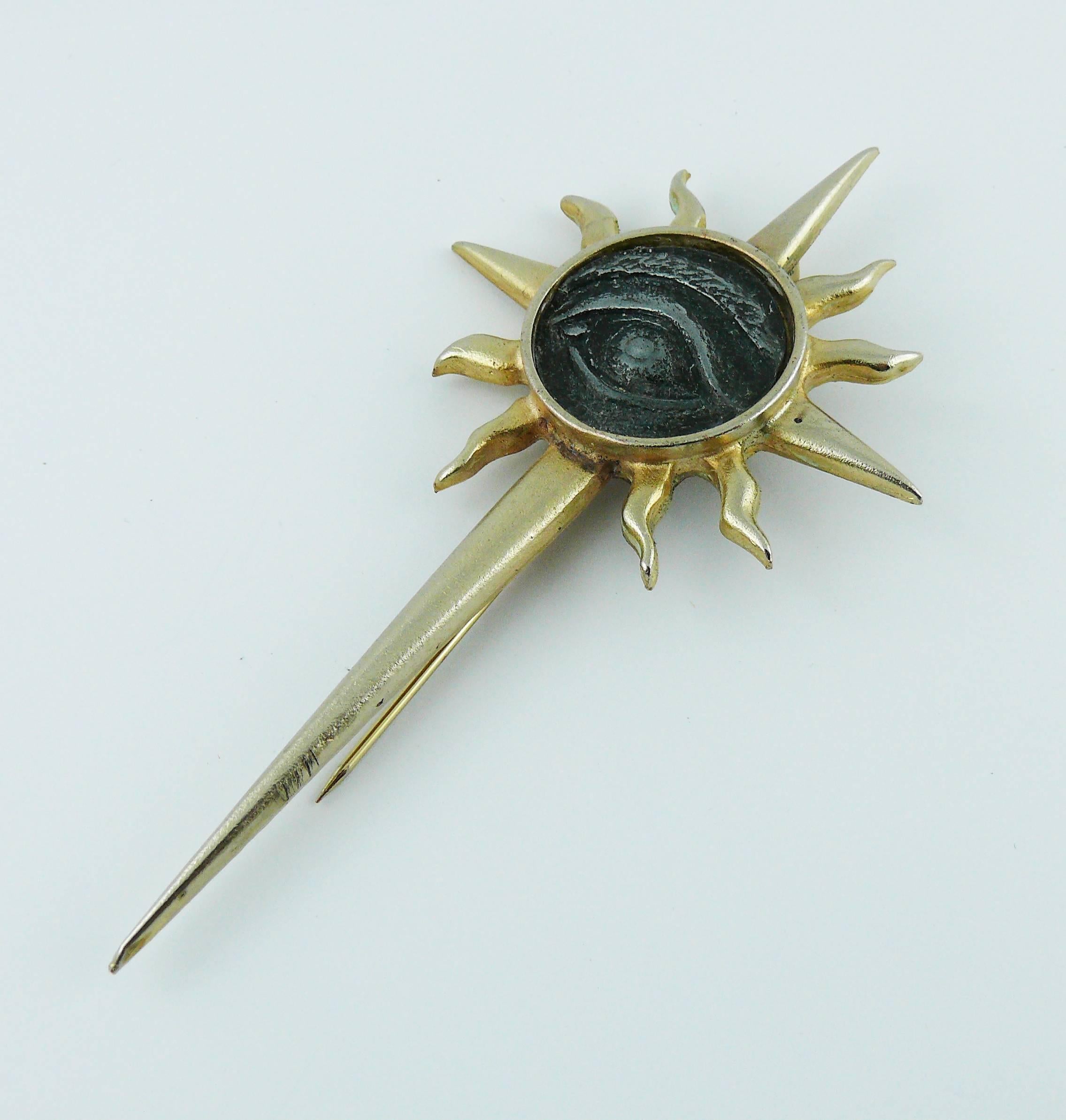 JEAN PAUL GAULTIER vintage rare pale gold toned brooch featuring a radiant sun and a distressed black Egyptian eye coin insert.

Embossed JEAN PAUL GAULTIER.

Indicative measurements : height approx. 11 cm (4.33 inches) / max. width approx. 5.5 cm