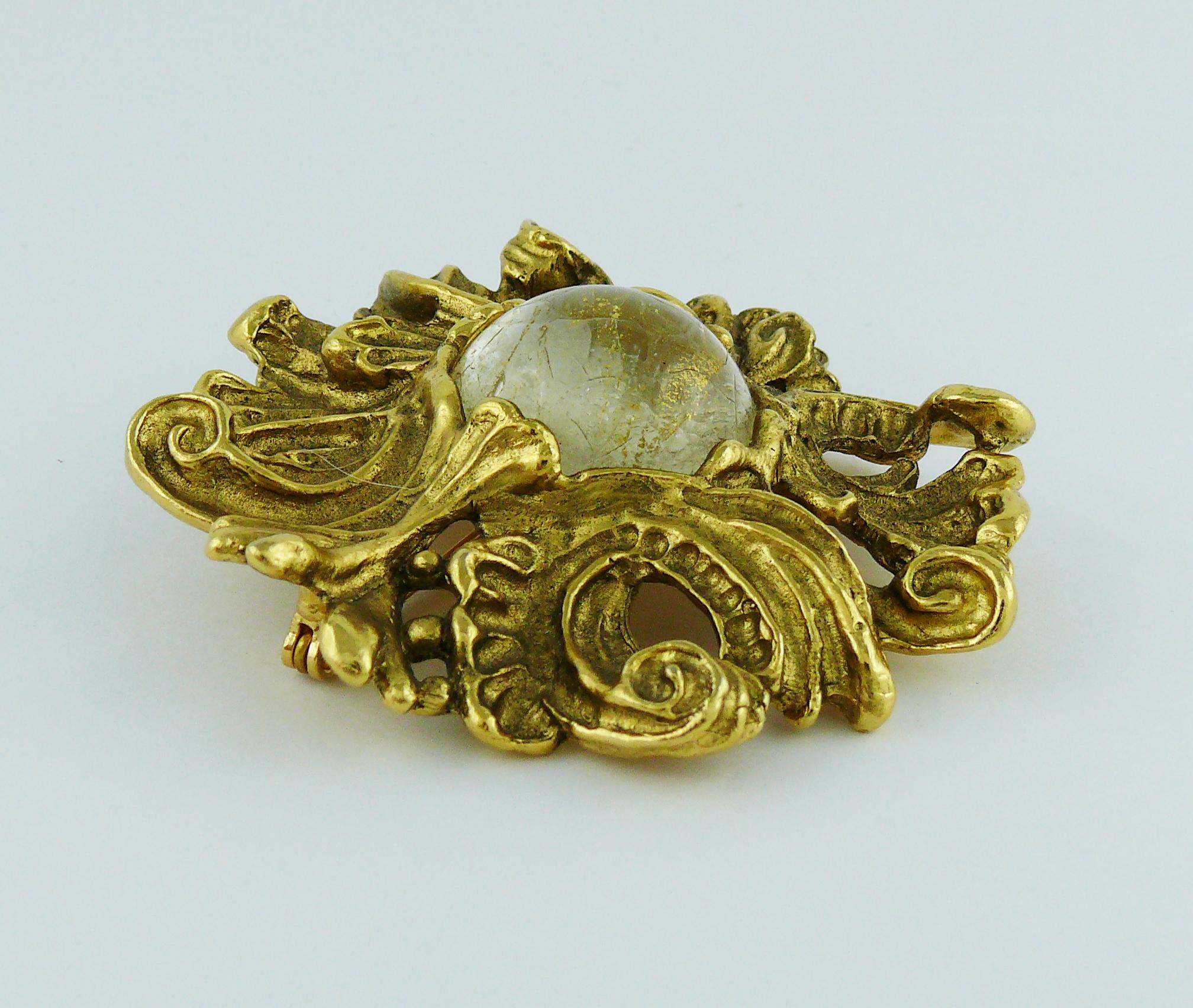 CHRISTIAN DIOR vintage antiqued gold tone Baroque brooch/pendant featuring a clear glass cabochon center with gilt inclusions and surface crack lines.

Marked CHRISTIAN DIOR Boutique.

Indicative measurements : approx. 6.7 cm (2.64 inches) x 6.9 cm