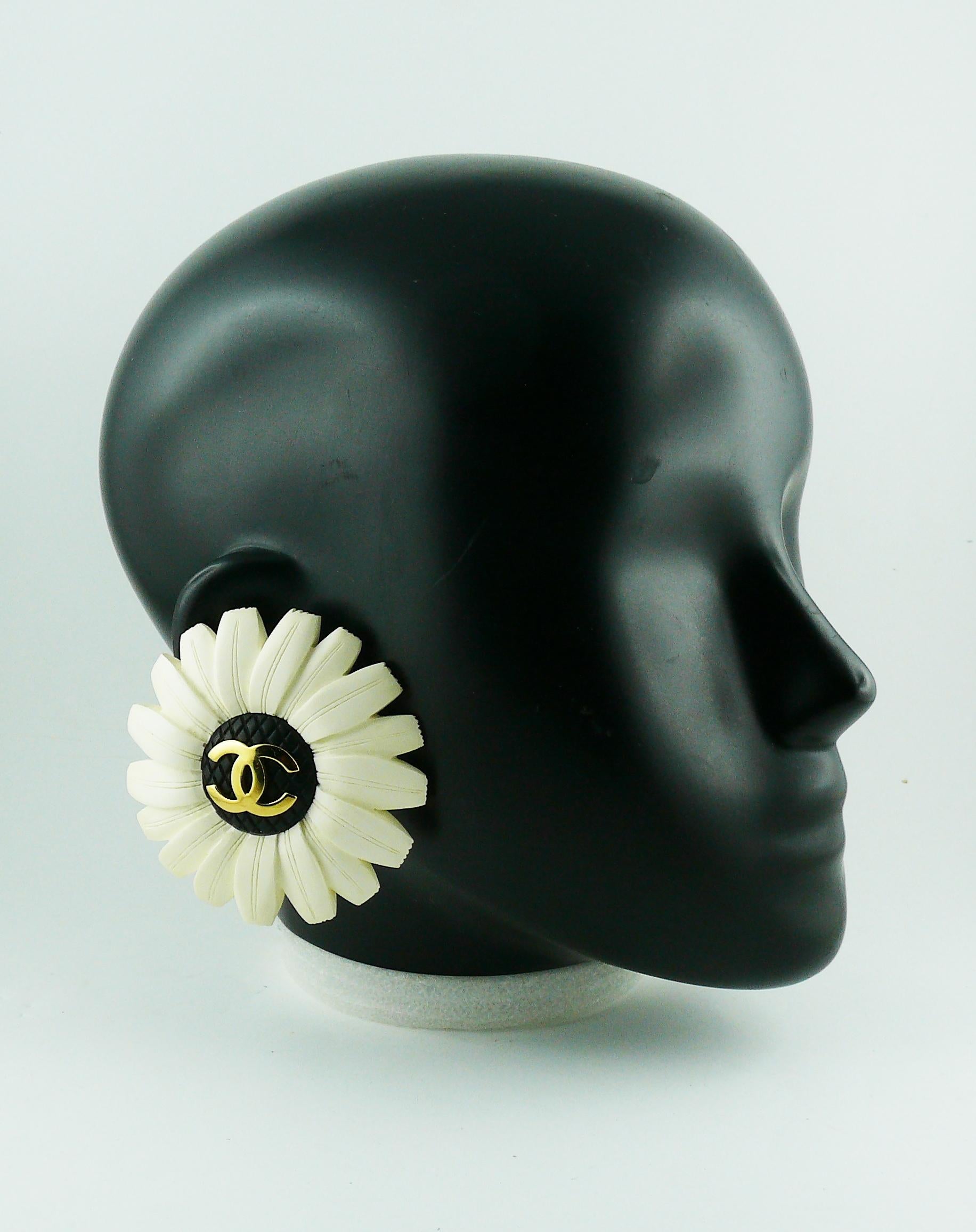 CHANEL vintage rare oversized white resin flower clip-on earrings featuring a gold toned CC monogram at center.

Embossed CHANEL.

Indicative measurements : diameter approx. 7 cm (2.76 inches).

JEWELRY CONDITION CHART
- New or never worn : item is
