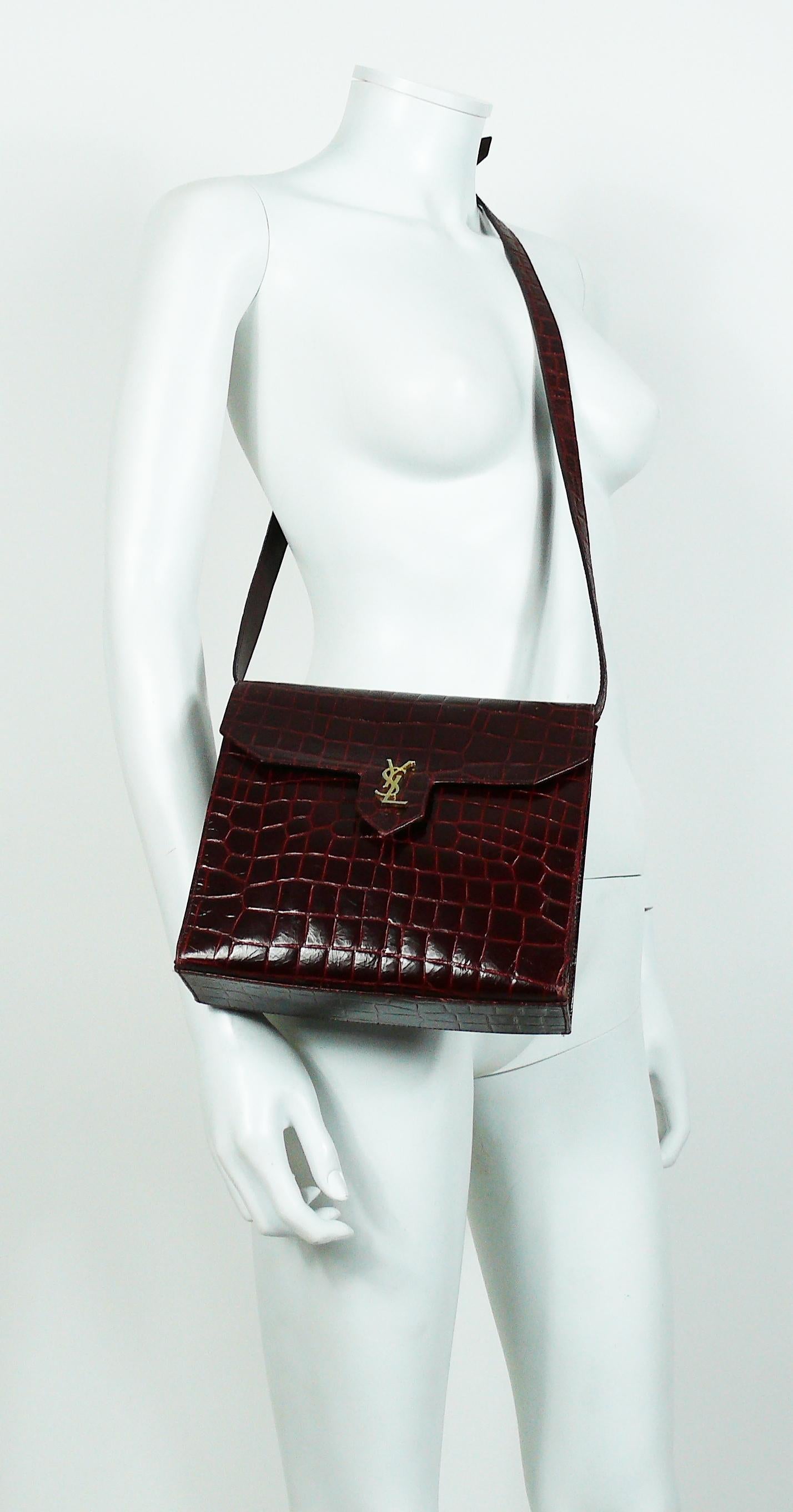 YVES SAINT LAURENT vintage bordeaux red leather croc embossed shoulder bag.

Can be also worn as a clutch.

This bag features :
- Bordeaux red leather croc embossed body.
- Gold toned YSL logo at front.
- Snap button closure.
- Black fabric lining