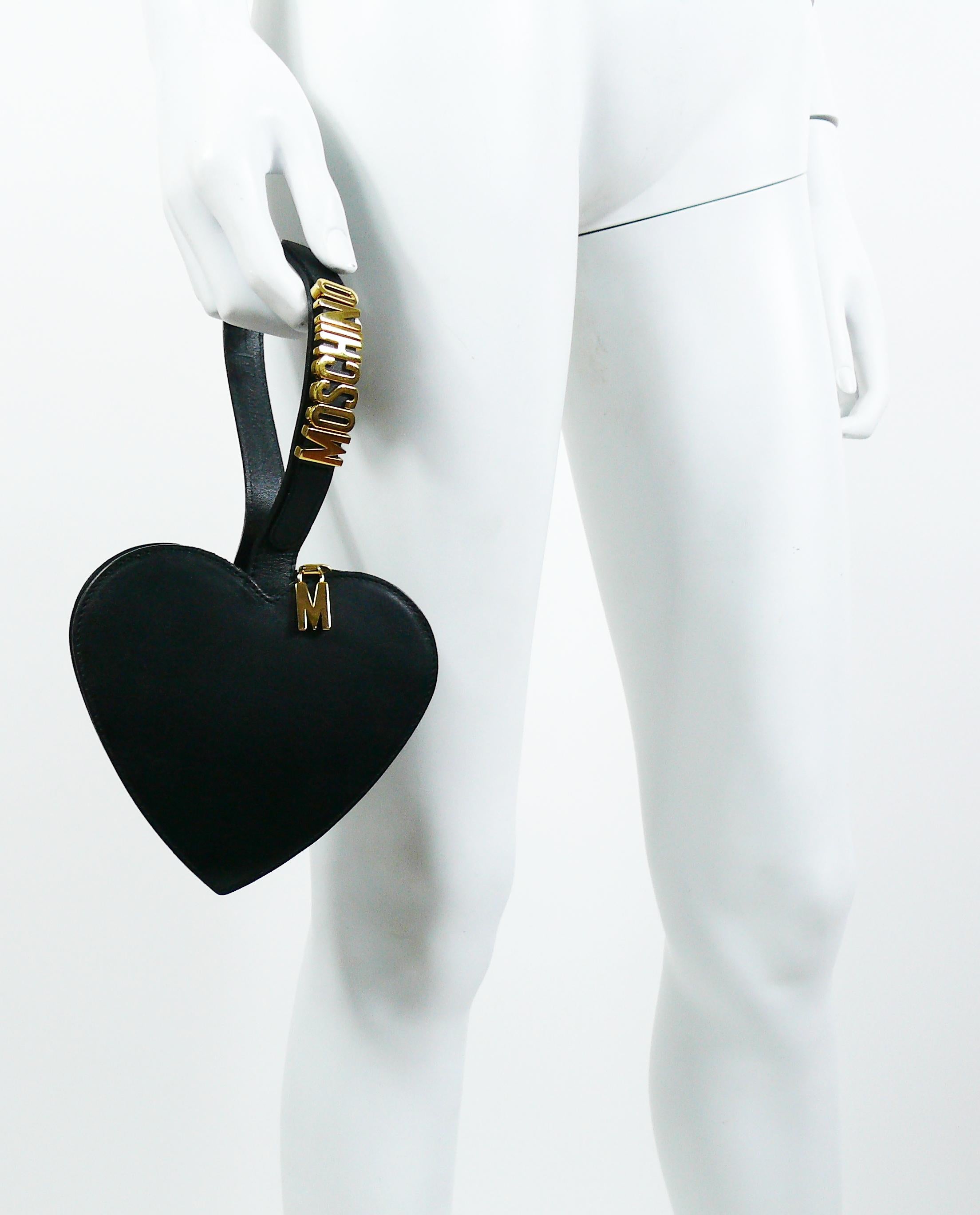 MOSCHINO Vintage-Armbandtasche aus schwarzem Leder mit Herz. 

Merkmale dieser Tasche: 
- Herzförmiger Korpus aus schwarzem Leder (Vorder-/Rückseite/Griff) und schwarzem Nylon (Seiten)
- Goldfarbene MOSCHINO-Schriftzüge am Griff. 
- Reißverschluss.