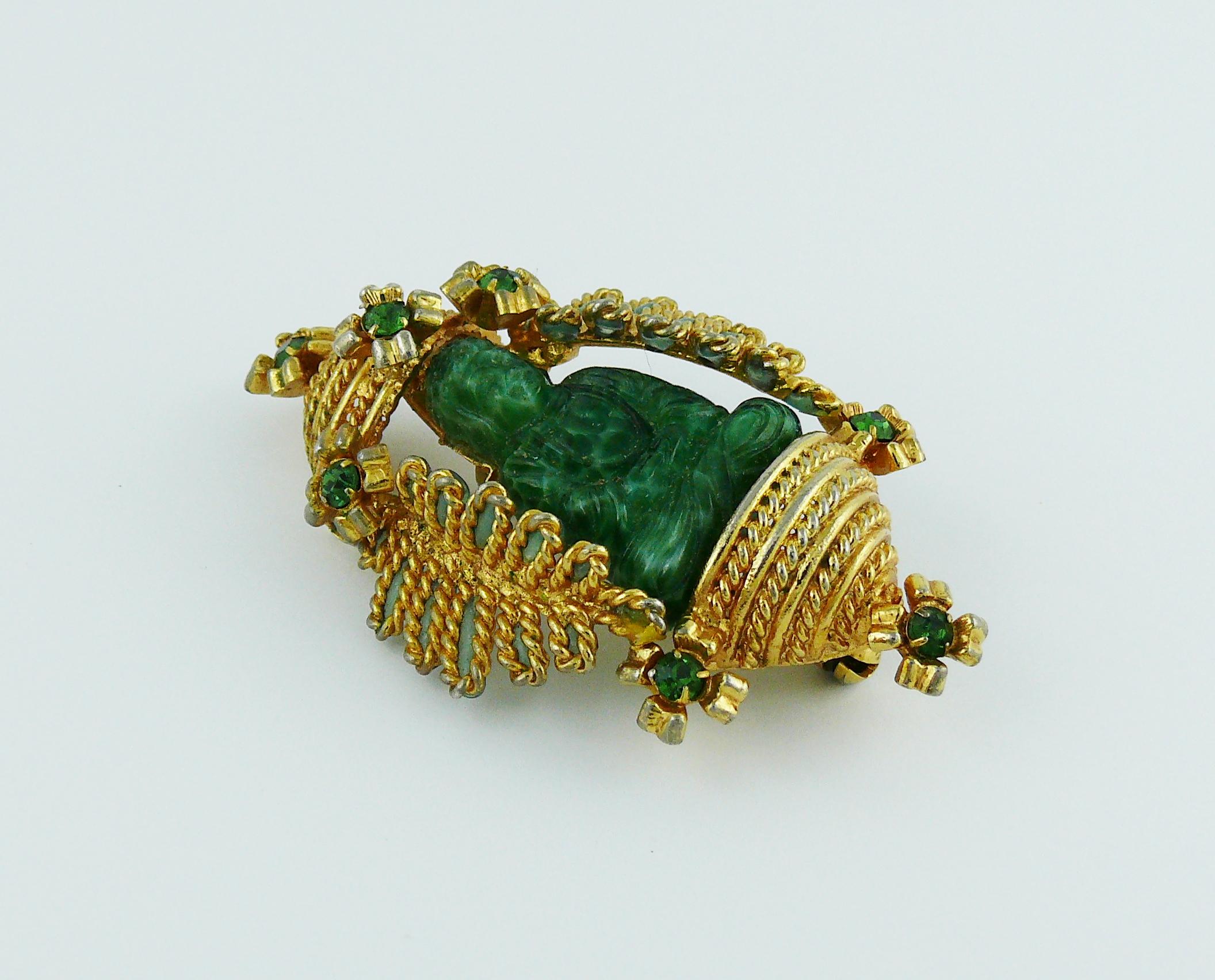 CHRISTIAN DIOR vintage rare 1967 brooch featuring a jade green resin buddha seating in a gold toned temple design setting with green crystal embellishement.

Marked 19 CHR. DIOR 67.
Made in Germany.

Indicative measurements : approx. 5.5 cm (2.17