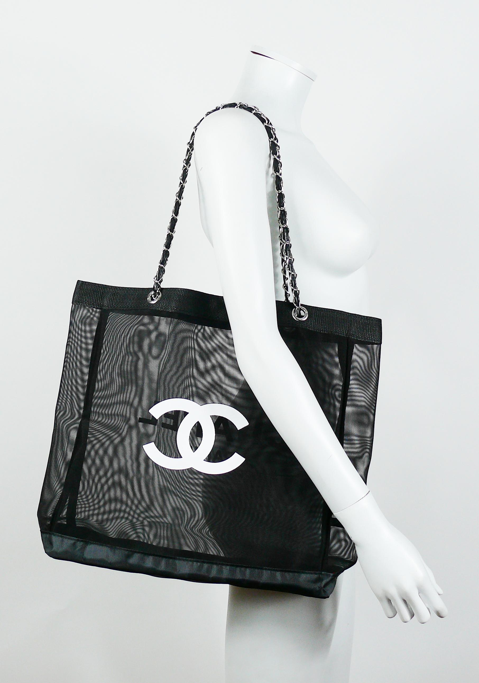 Chanel black mesh tote shopping gift bag.

This bag features :
- Black mesh body with black nylon base and top trim.
- White flocked Chanel Paris on one side and CC logo on the other.
- Silver toned chains with intertwined black faux leather (PVC)