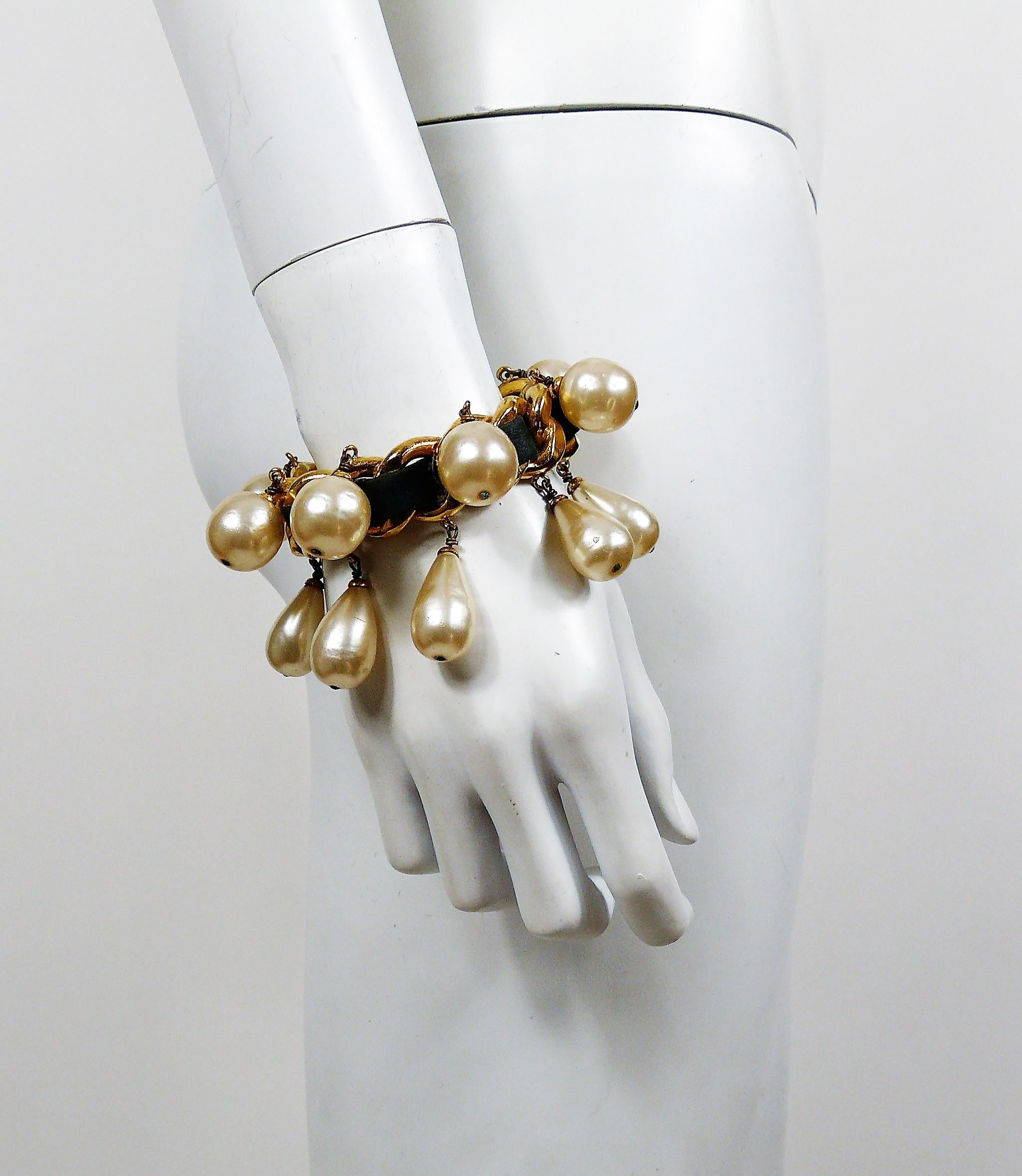 Chanel vintage rare gold toned woven chain and black leather rigid cuff bracelet featuring large dangling glass faux pearls.

Collection year : 1988.

Marked CHANEL 2 3 Made in France.
Engraved S for private sale.

Indicative measurements : inner