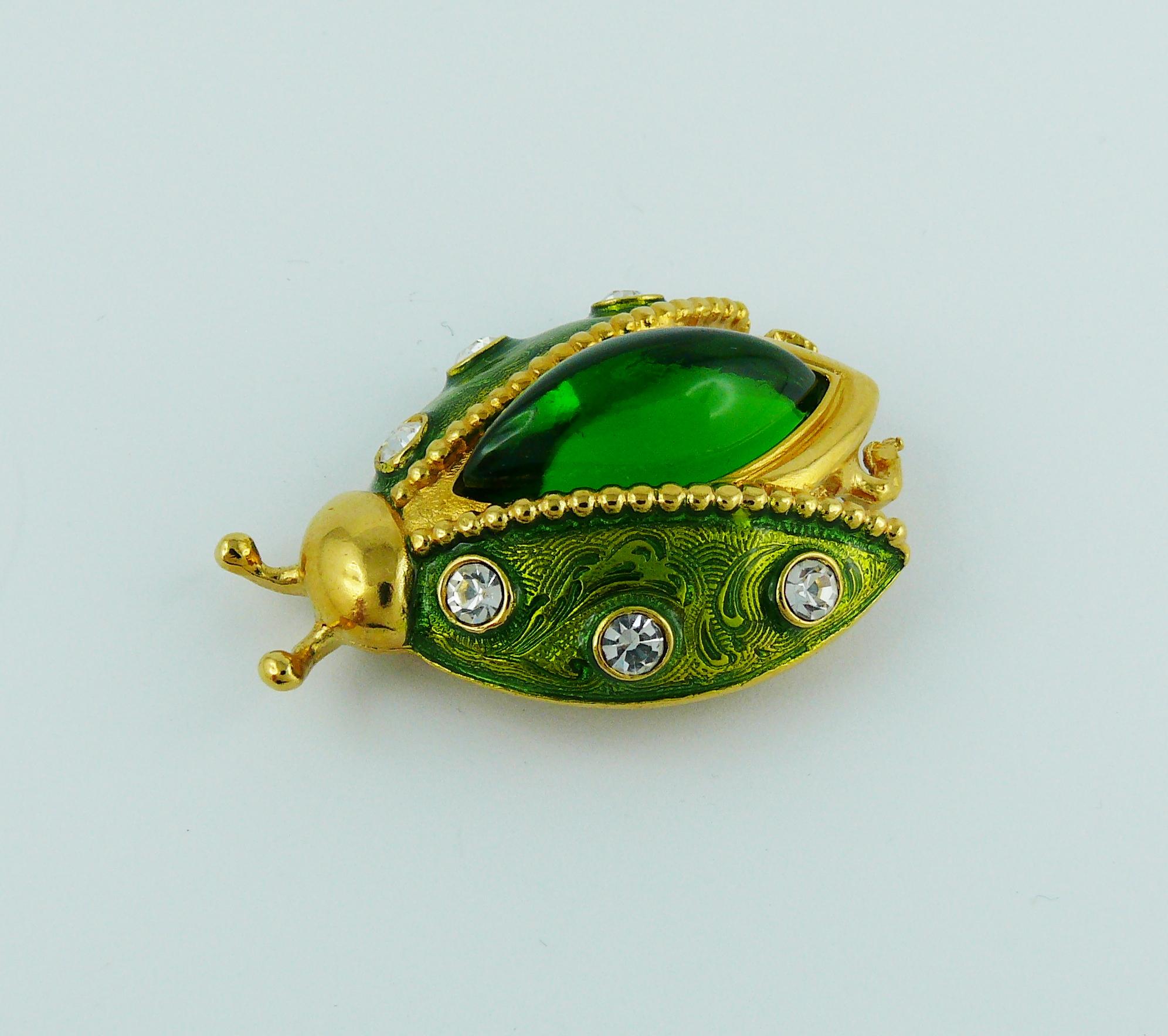CHRISTIAN DIOR vintage rare jeweled ladybug brooch.

Enameled gold tone metal, embellished with white rhinestones and a green resin domed almond cabochon.

Marked PARFUMS CHRISTIAN DIOR.

Indicative measurements : max. length approx. 4.2 cm (1.65
