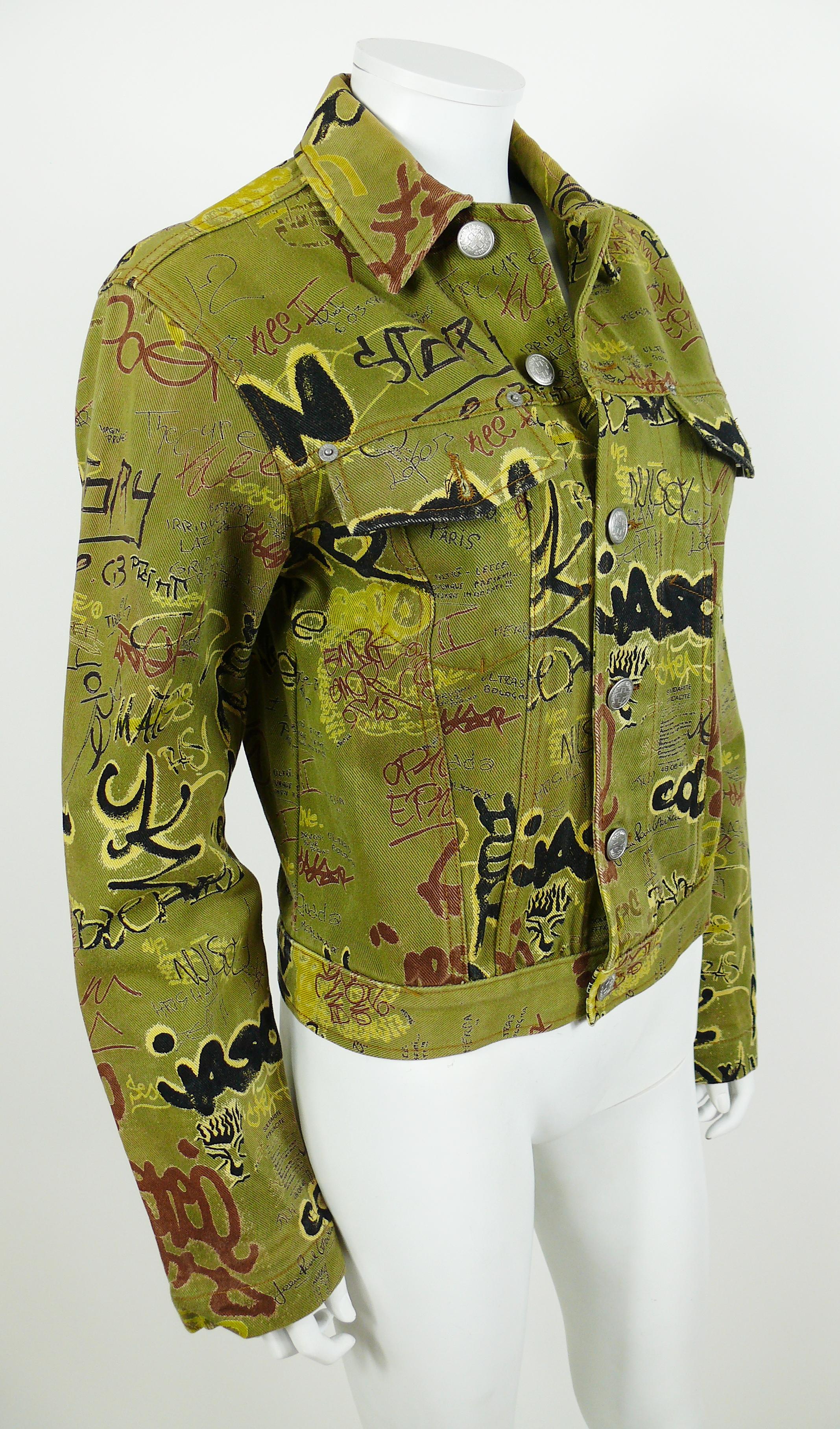 JEAN PAUL GAULTIER vintage khaki denim jacket featuring a multi colored graffiti print all over.

This jacket features :
- Classic collar.
- Two chest pockets with buttons (shown on photo 4).
- Front and cuff buttoning.
- Silver toned GAULTIER