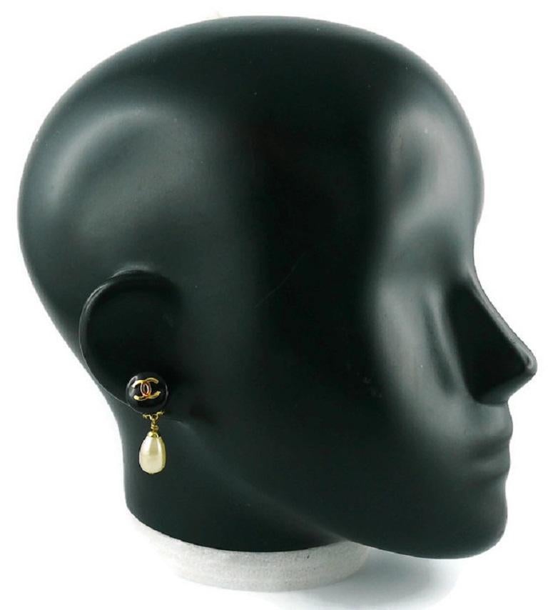 CHANEL vintage dangling earrings (clip-on) featuring a black resin dome top with CC logo at center and a faux pearl drop.

Fall 1994 Collection.

Marked CHANEL 94 A Made in France.

Indicative measurements : height approx. 3.5 cm (1.38 inches) /