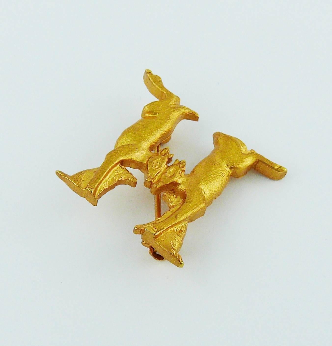 HERMES vintage gold toned inverted twin rabbits with dogs forming the initial H.

Marked HERMES Parfums.

Indicative measurements : height approx. 2.5 cm (0.98 inch) / max. width approx. 2.6 cm (1.02 inches).

JEWELRY CONDITION CHART
- New or never