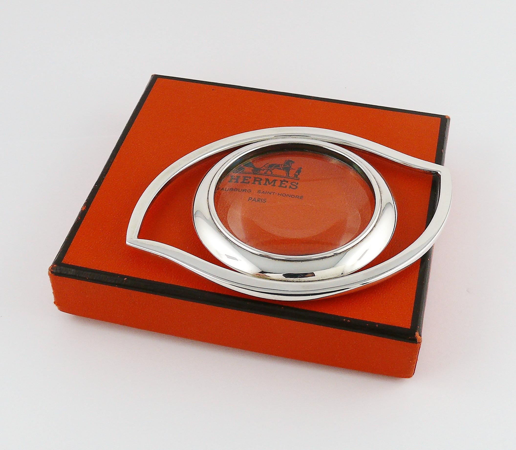 HERMES silver toned desk magnifying glass and paperweight featuring a massive Egyptian Mythology inspired CLEOPATRA Eye.

Originally designed in the 1960’s by JEAN COCTEAU for the House of HERMES.

Can be worn also as a pendant.

Embossed HERMES