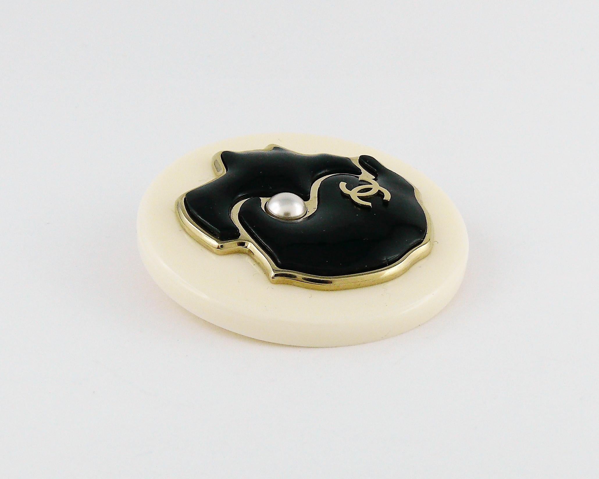 CHANEL black and white resin COCO profile brooch embellished with a faux pearl and silver toned CC logo.

Marked CHANEL G18 B Made in Italy.

Indicative measurements : diameter approx. 4.9 cm (1.93 inches).

Comes with original box.

JEWELRY