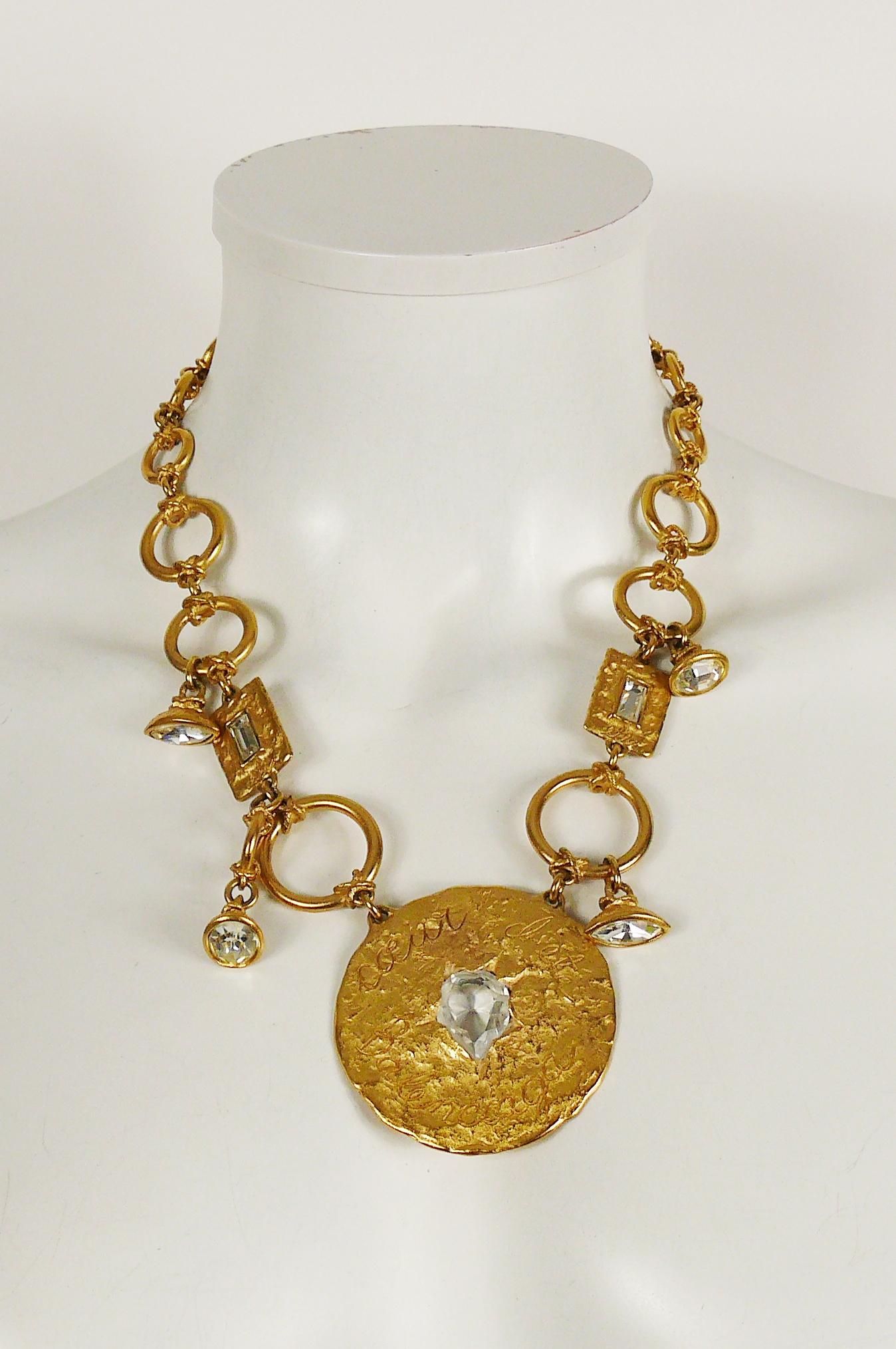 BALENCIAGA vintage gold toned necklace featuring a large textured disc embossed CŒUR D’ÉTÉ BALENCIAGA embellished with clear crystal.

T-bar closure.

Embossed BALENCIAGA Paris.
Made in France.

Indicative measurements : chain length approx. 51.5 cm