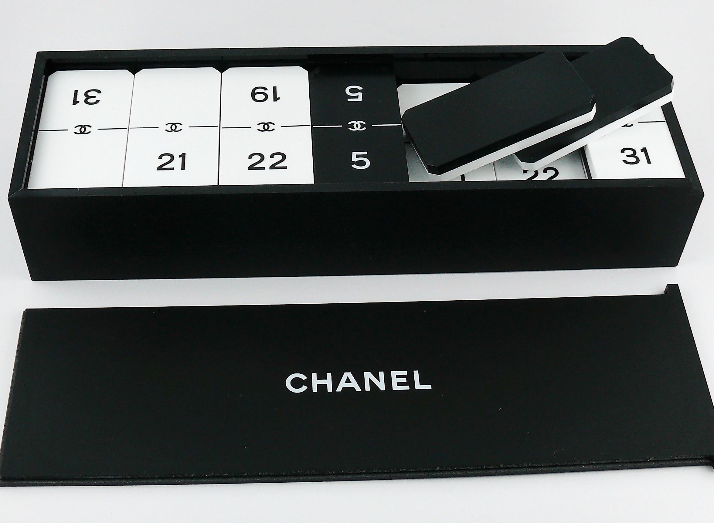 CHANEL promotional gift domino set.

Deck of 28 pieces (27 white and 1 black) with CHANEL CC logo in a matching hard case.

Please that this is not not a retail item.

Comes with original cardboard packaging box (used condition / see photos 5 to