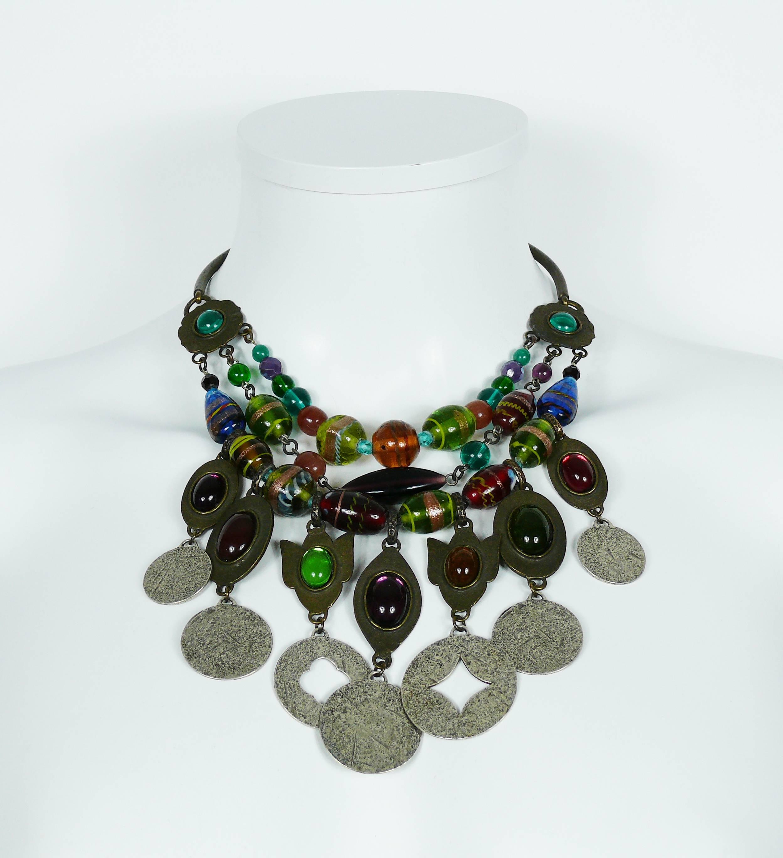 PHILIPPE FERRANDIS antique patina finish bib necklace, featuring three glass bead strands.
 
Necklace features seven metal charms, some perforated and some others with oval shaped glass cabochons.

Hook clasp.
Extension chain.

Marked PHILIPPE