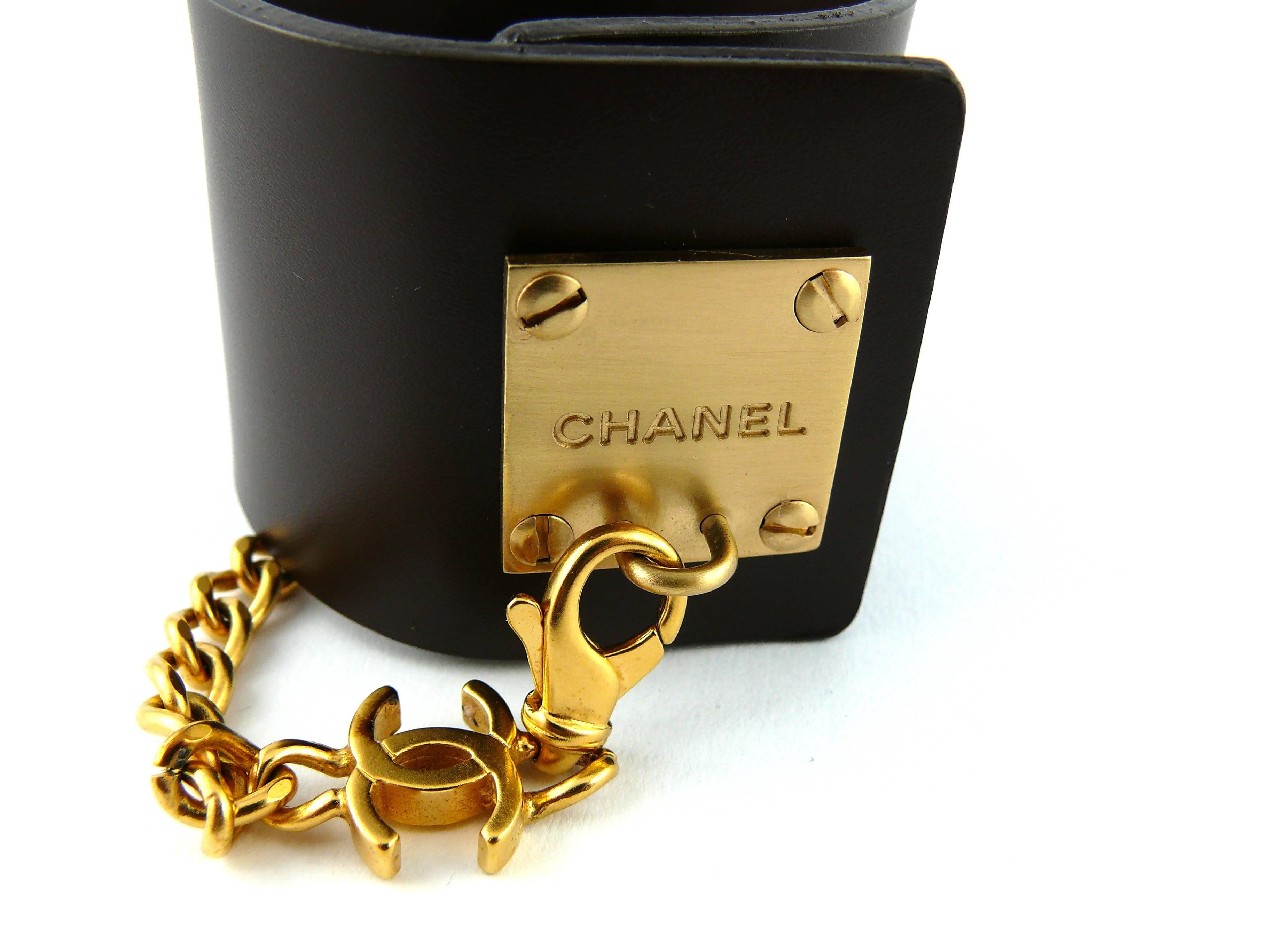 CHANEL gorgeous brown leather cuff bracelet featuring a gold tone ID tag plaque embossed with Chanel logo.

Bracelet is adorned with a chain and CC monogram.

Marked Chanel 03 P Made in France.

Comes with its original box